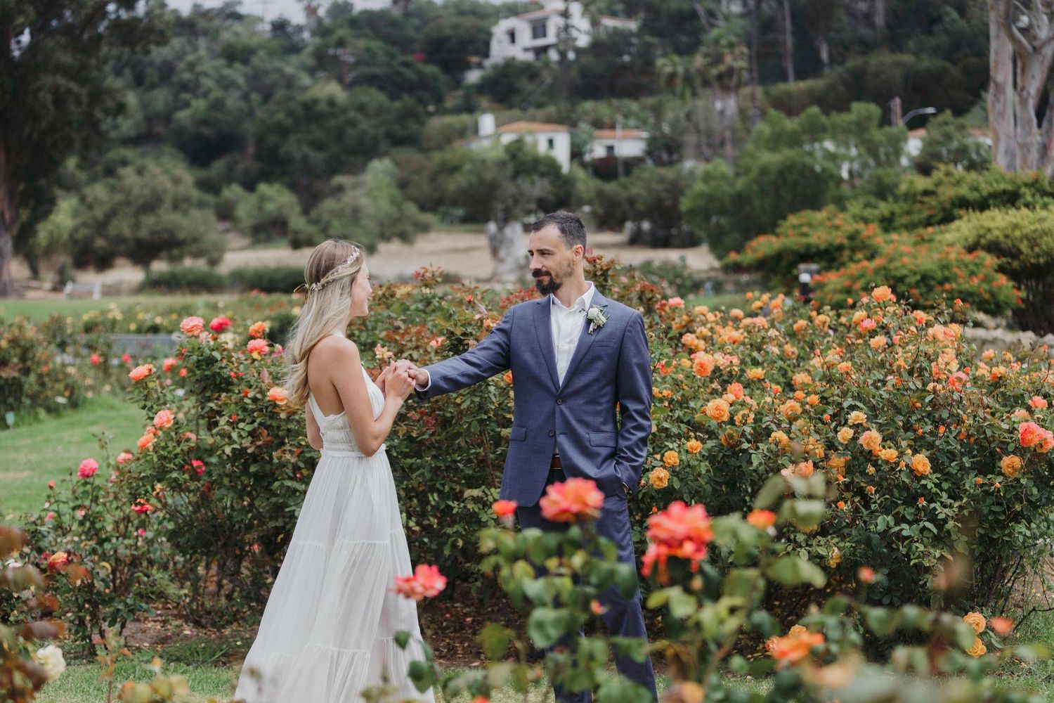 Romantic garden wedding scene surrounded by vibrant orange and yellow flowers in full bloom.