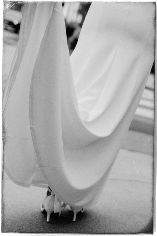 A sequence of black and white photographs showing the flowing movement of a wedding dress hem and shoes while walking.
