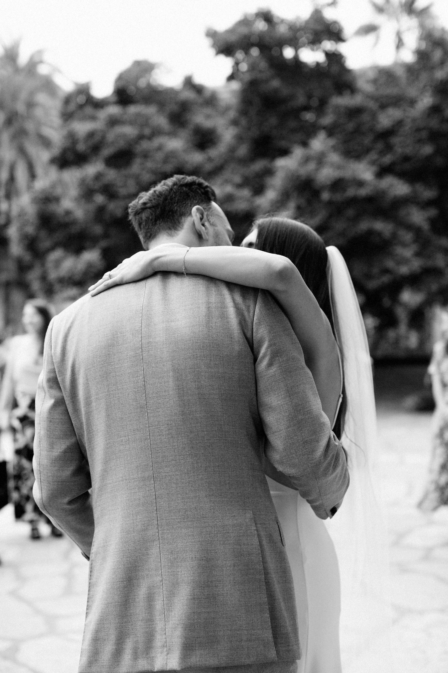 A sequence of black and white photos showing a couple embracing, with focus on their shoulders and heads from behind.