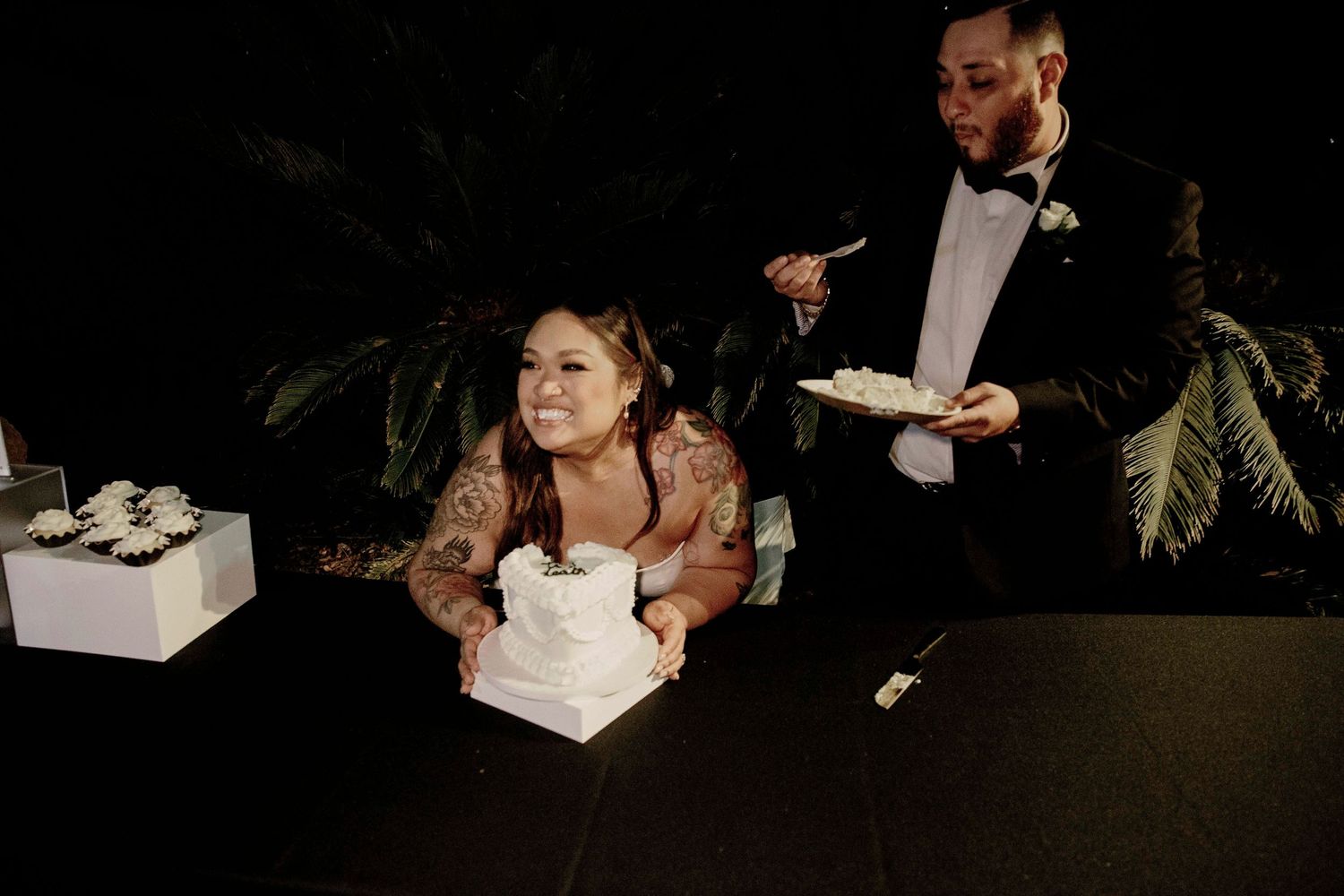 Elegant wedding party dances together in formal attire at an evening reception celebration.