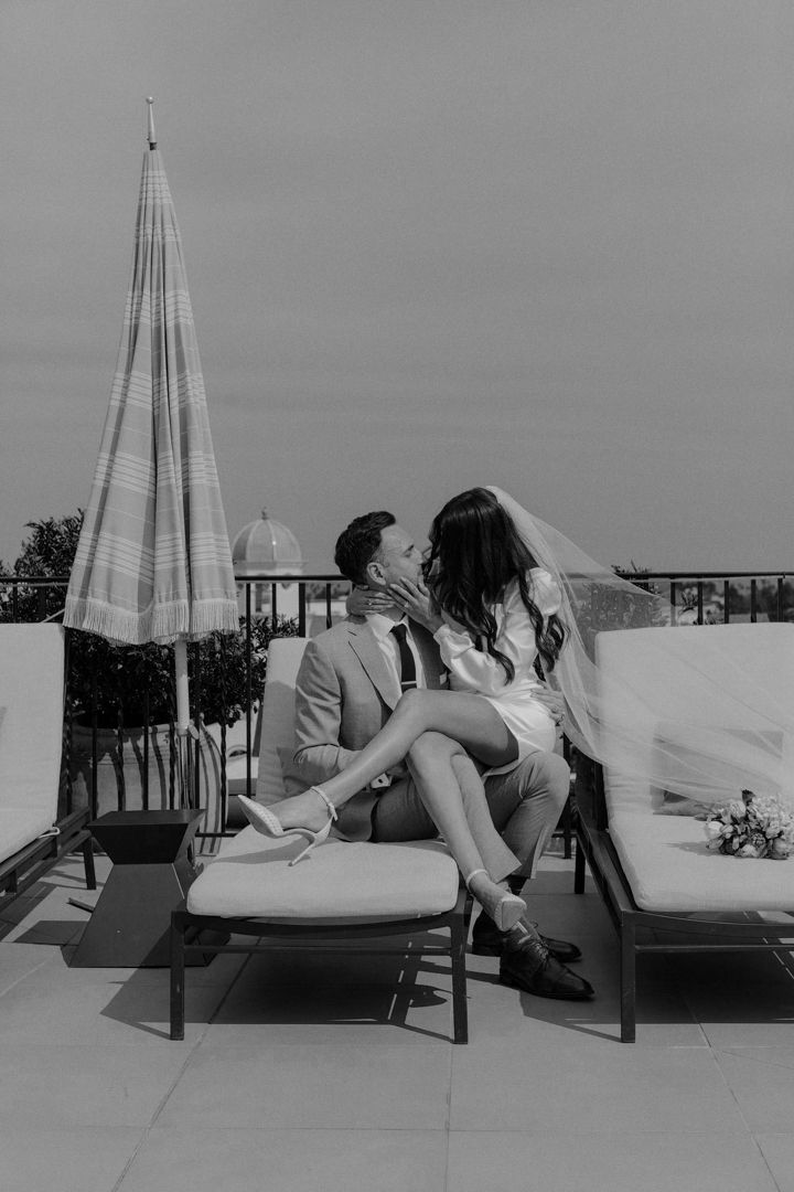 A sequence of black and white photos showing a couple lounging on a chaise lounge chair on a rooftop terrace.