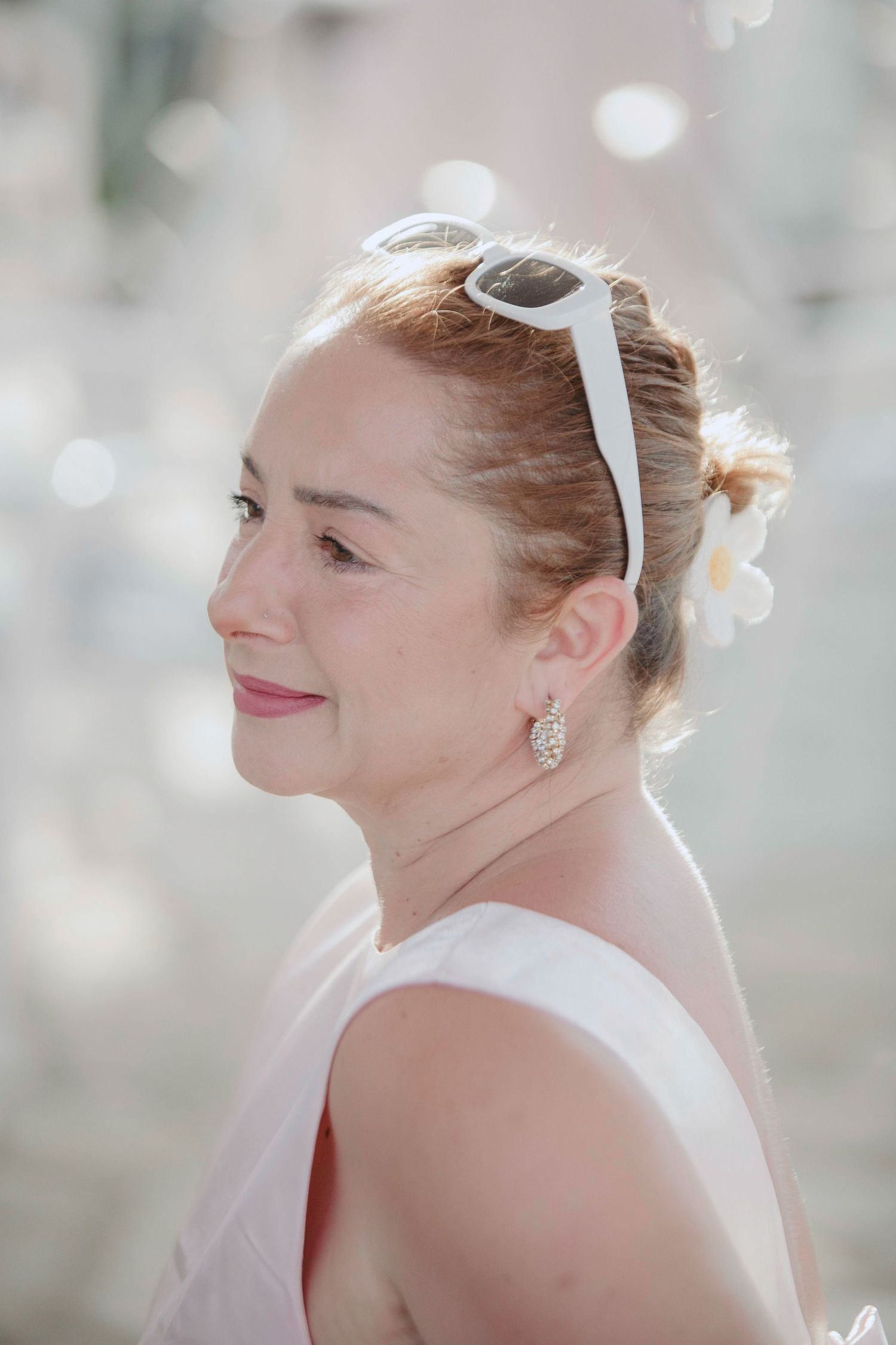 A series of profile shots showing someone wearing white sunglasses and smiling in soft lighting.