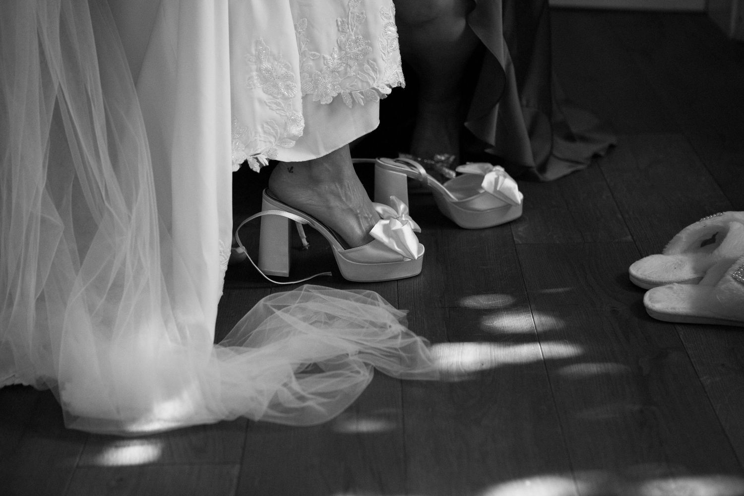 A sequence of black and white photos showing the flowing movement of a wedding dress and shoes on a dance floor.