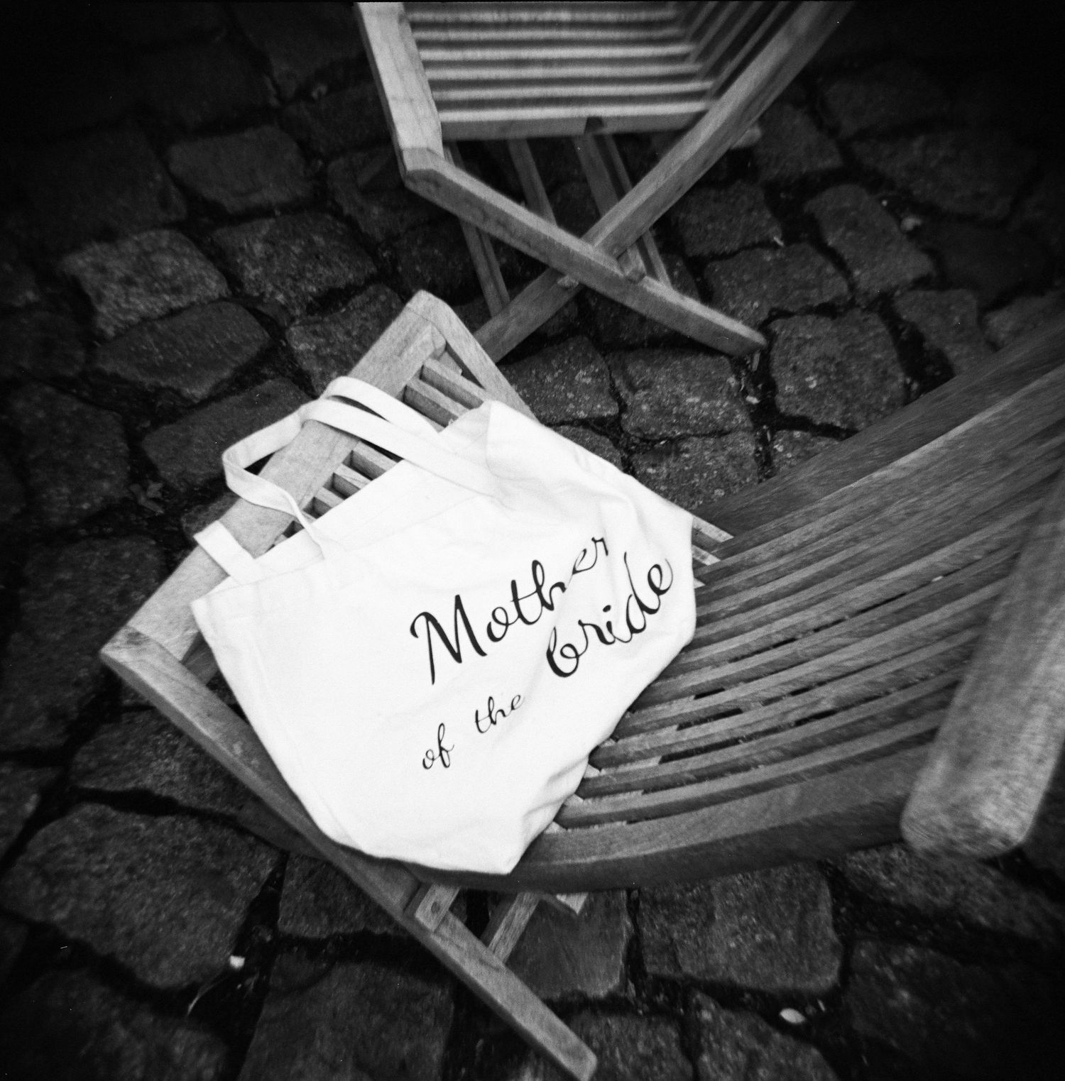 Black and white photo of handwritten notes scattered on a dark textured surface.