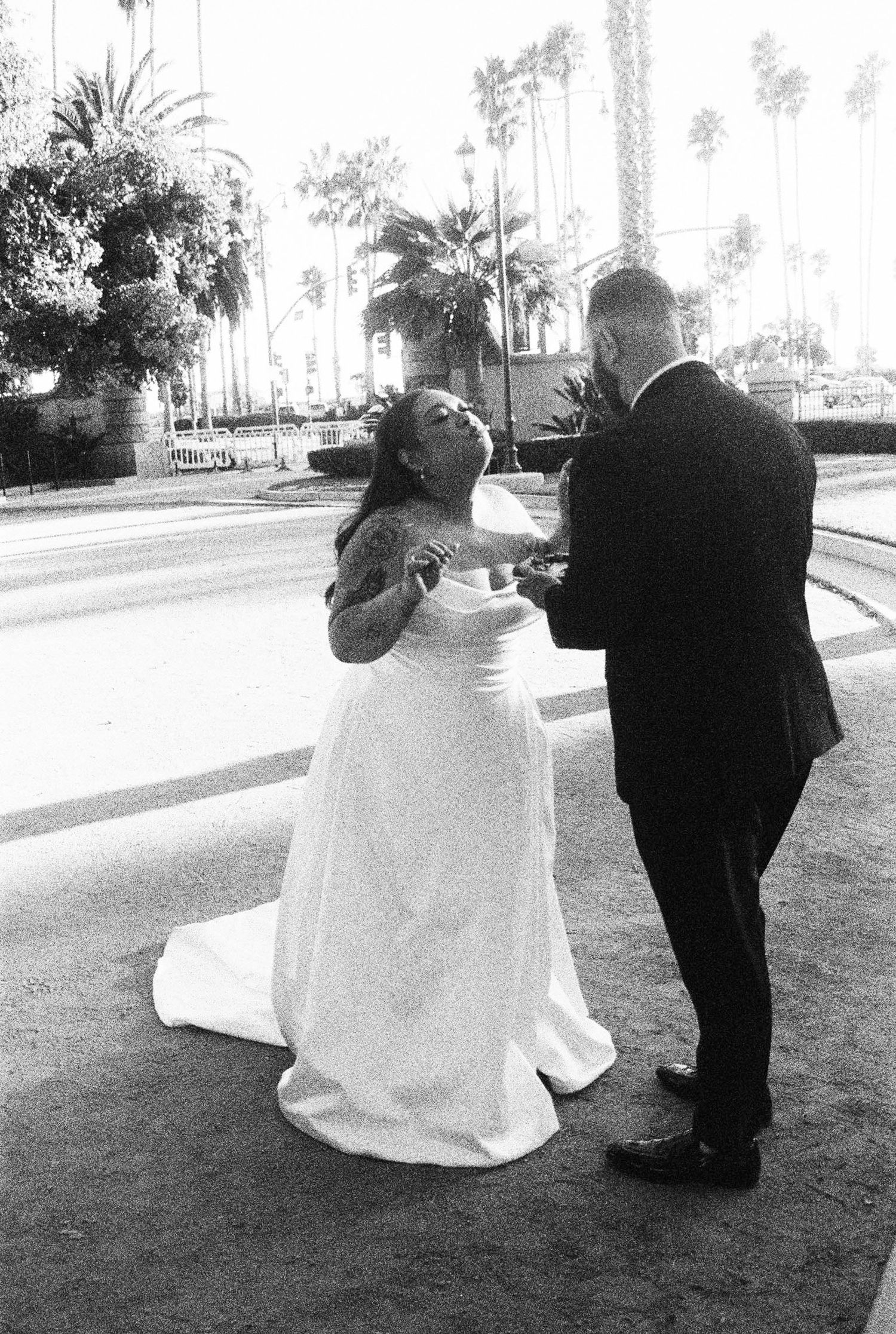 Black and white photo series showing a couple in wedding attire walking away together on a path through a garden setting.