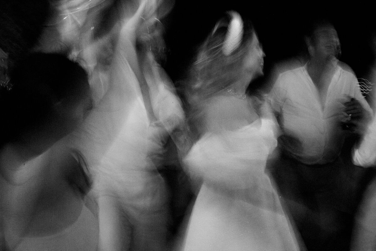A blurry black and white abstract image shows silhouettes of figures in motion creating a ghostly effect.