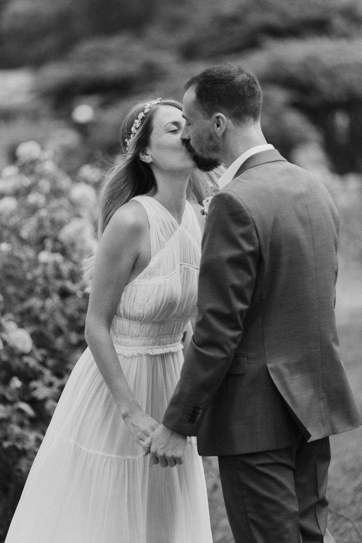 A romantic black and white photo sequence shows a couple in wedding attire sharing intimate moments in a garden setting.