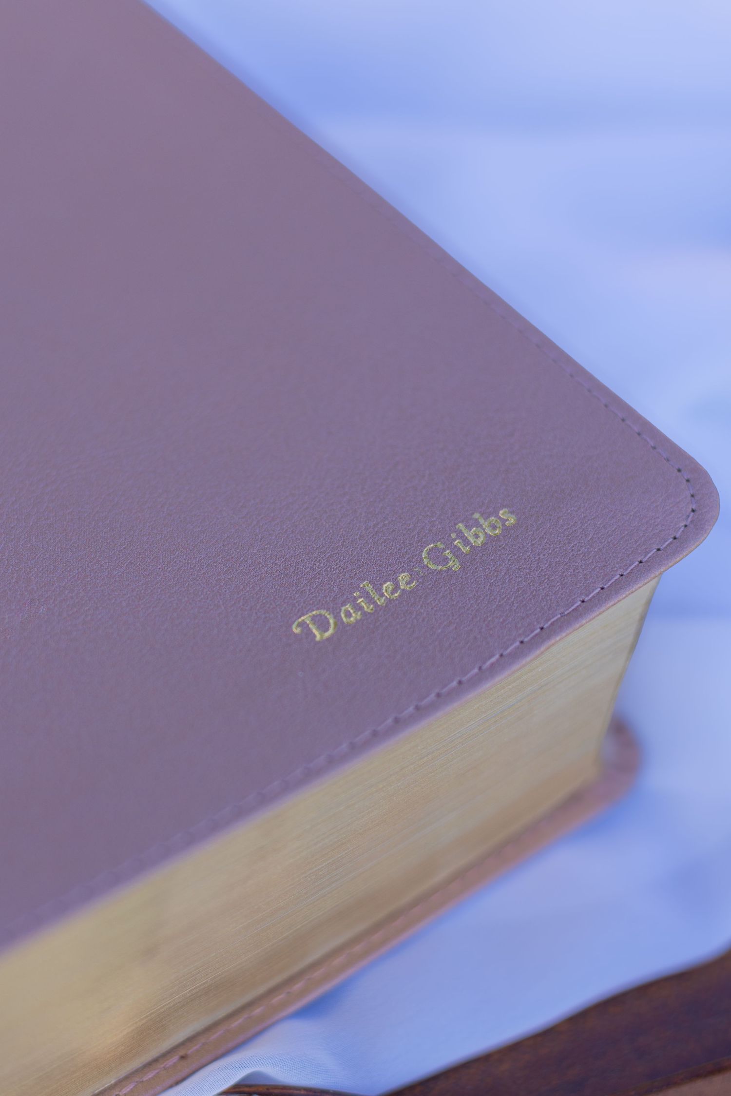 Close-up of a purple leather book cover with gold lettering detail.