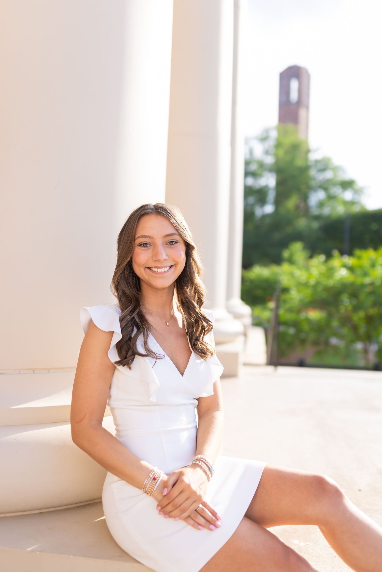 Portrait session in white dress against classical white columned architecture.