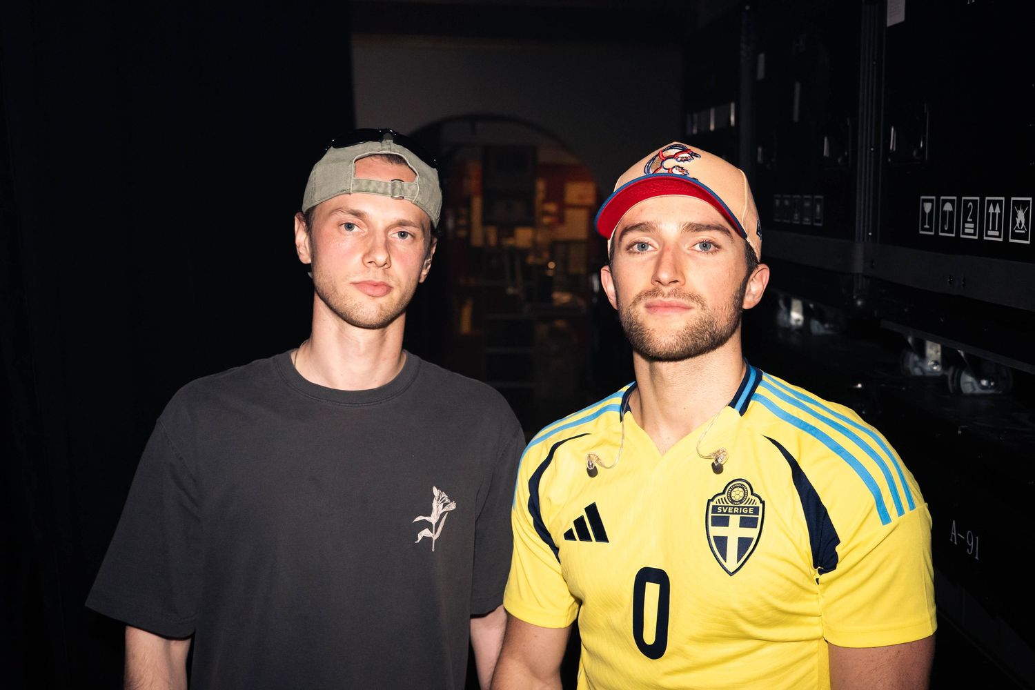 Two people pose together at night, one wearing a black t-shirt and one in a yellow soccer jersey.