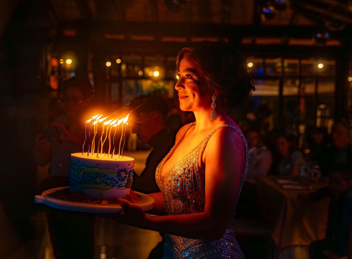 A sequence of illuminated birthday candles progressing from dark to bright glowing in a nighttime celebration setting.