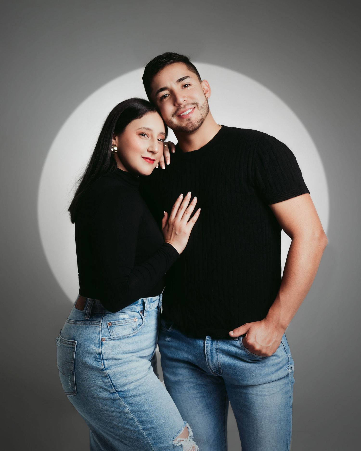 Studio portrait series featuring couple in casual denim and black outfits against grey backdrop.