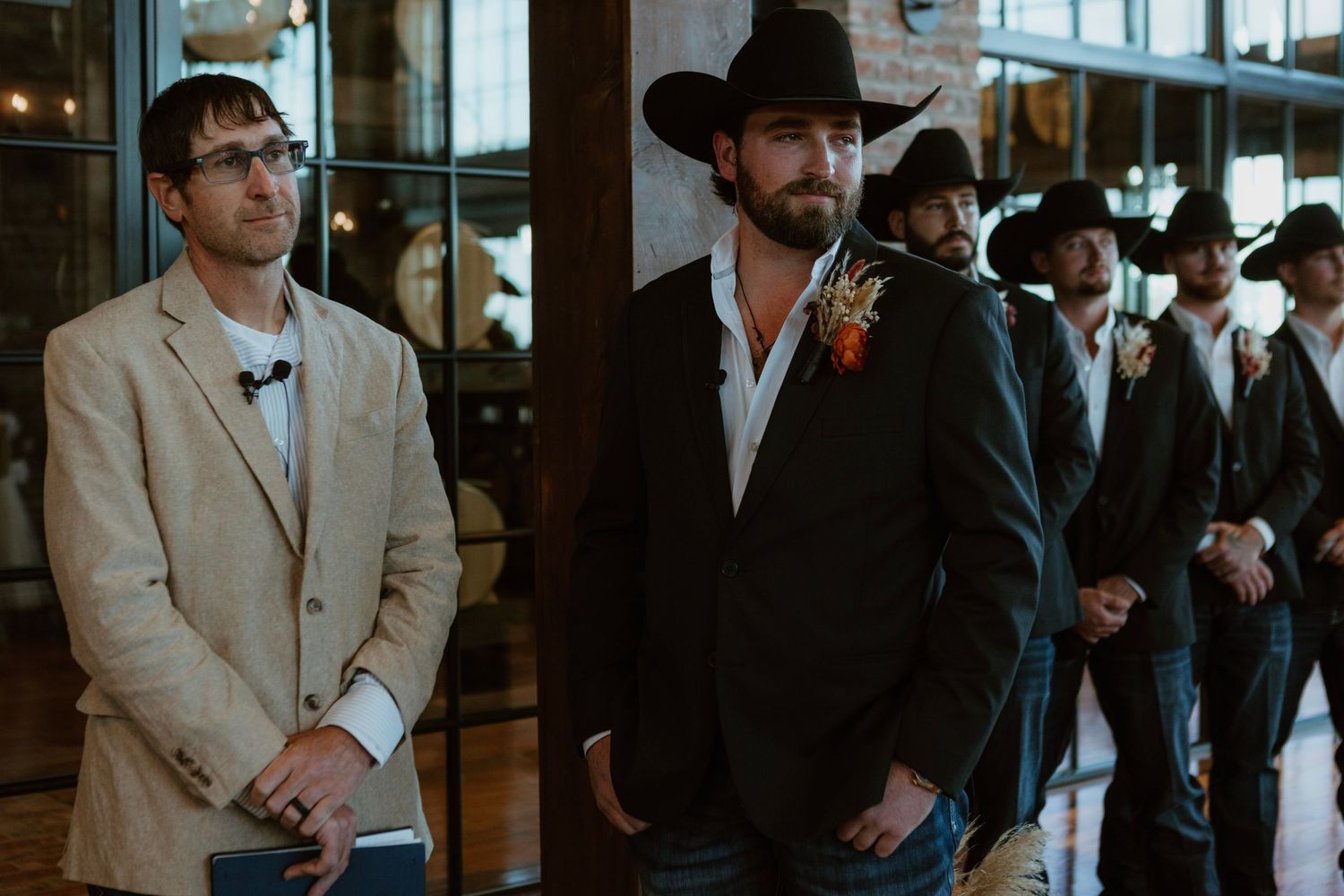 A row of formally dressed people standing in a line against a dark background.