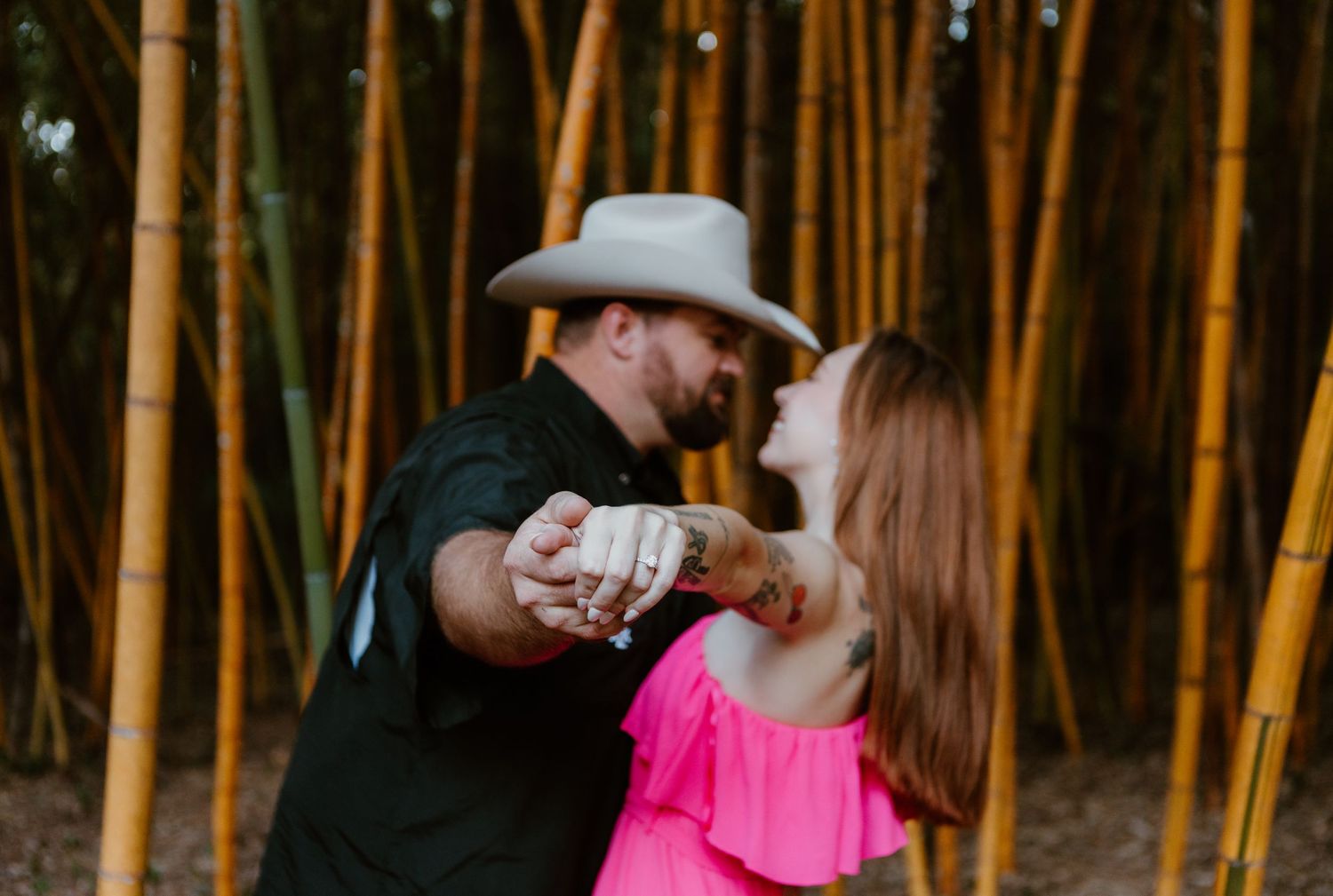 Couple sharing a romantic moment in a bamboo forest during golden hour sunset.