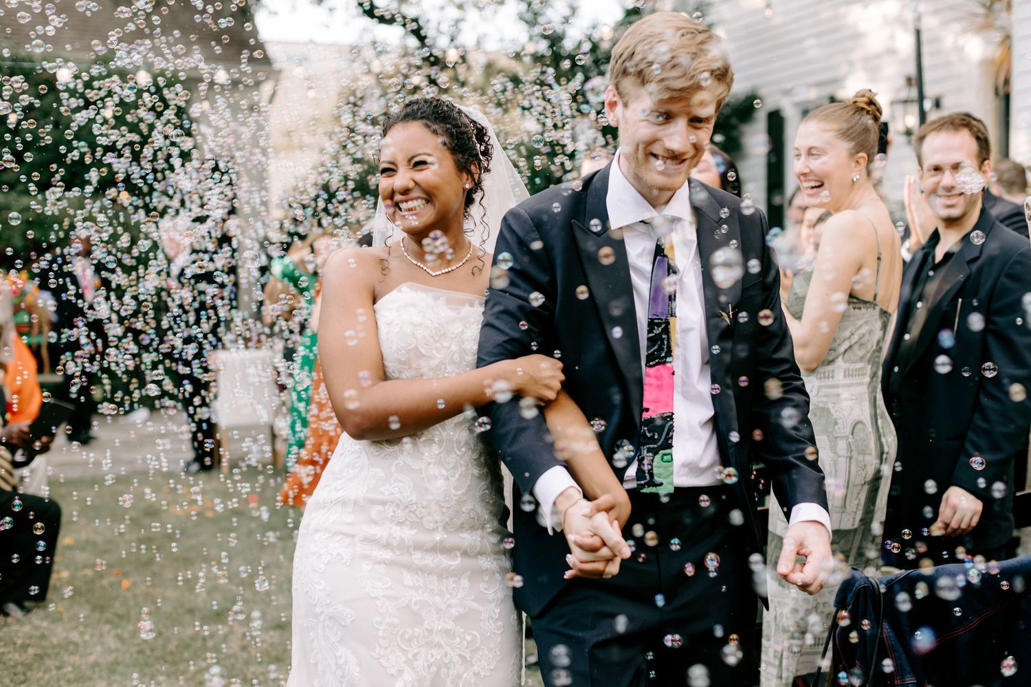 Newlyweds walk through a shower of bubbles outside on their joyful wedding day In New Orleans Louisiana.