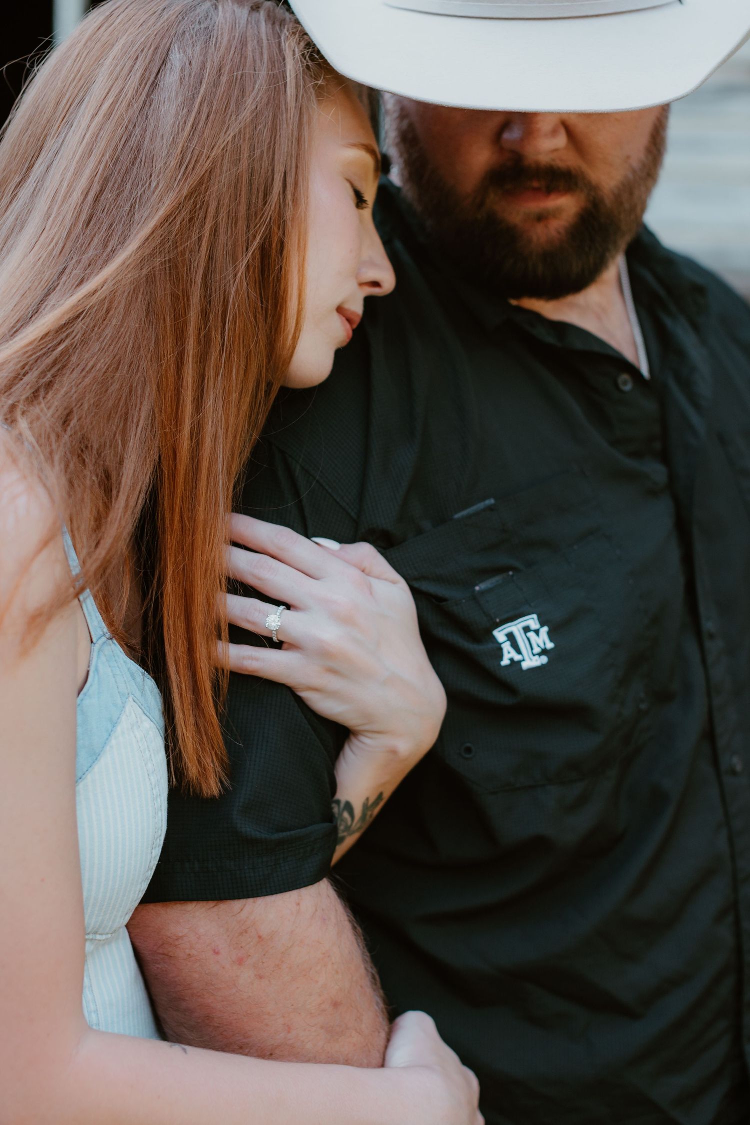 Romantic couple in intimate poses showing affection while one wears a black polo shirt with A&M logo.