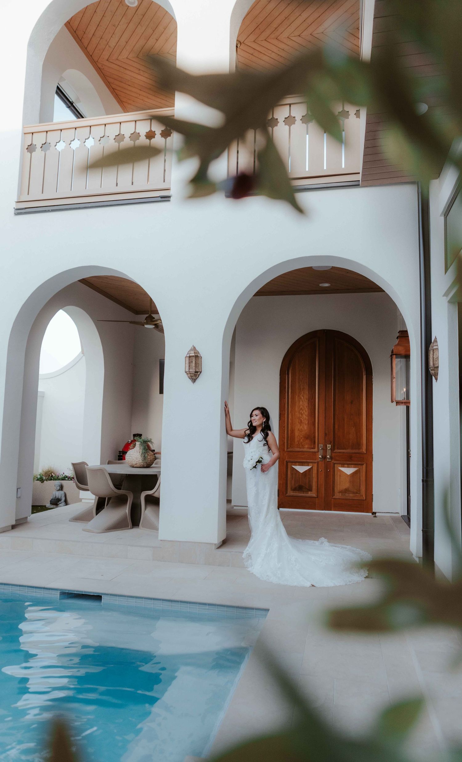 Mediterranean style luxury villa interior with white arched doorways, wooden doors and small swimming pool in courtyard.
