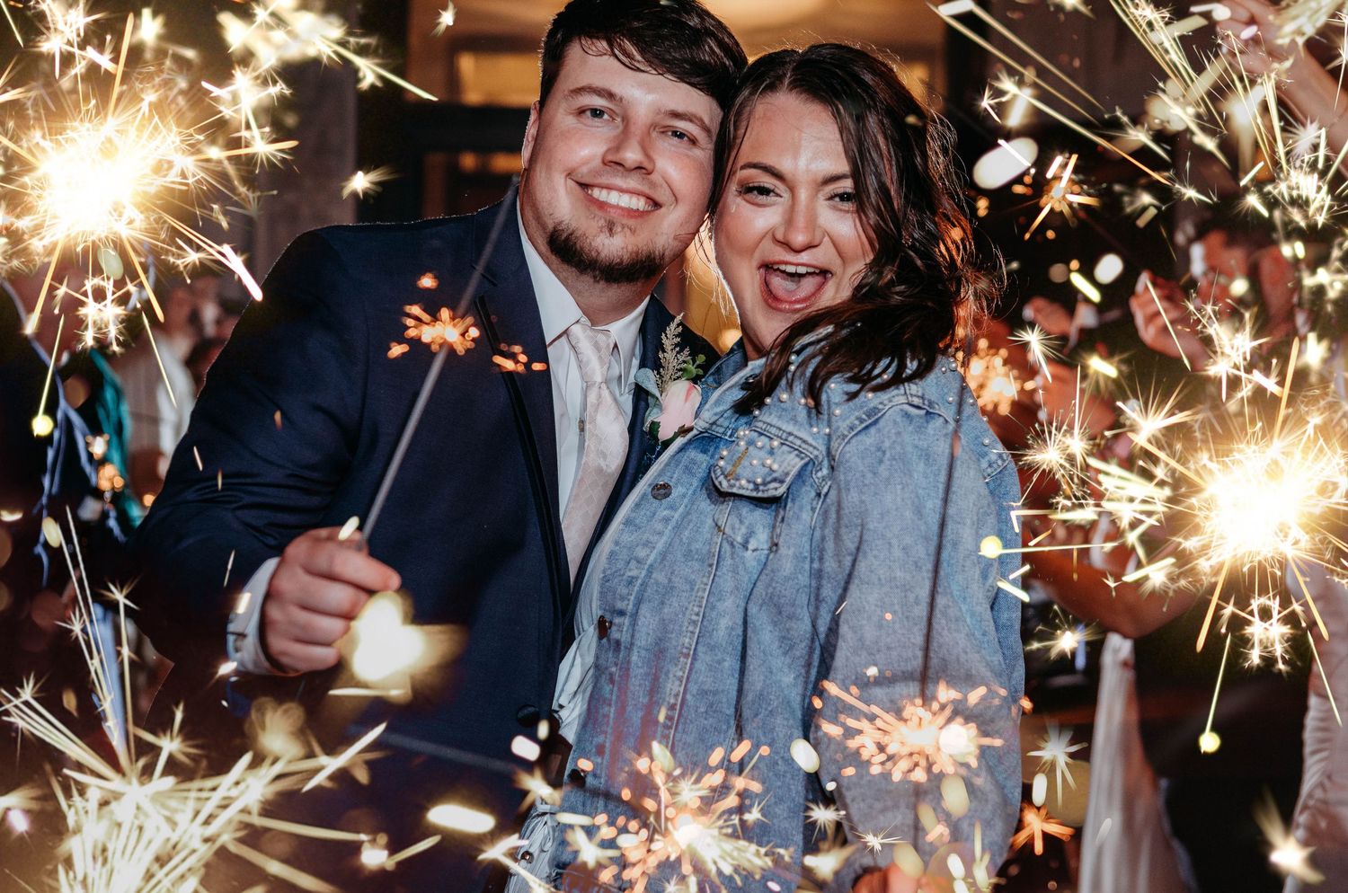 People celebrate with sparklers at a festive nighttime event, creating a magical atmosphere of light and joy.