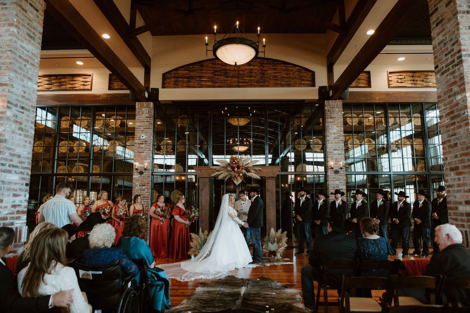 Elegant wedding reception venue with exposed wooden beams, stone walls and warm lighting creating a rustic atmosphere.