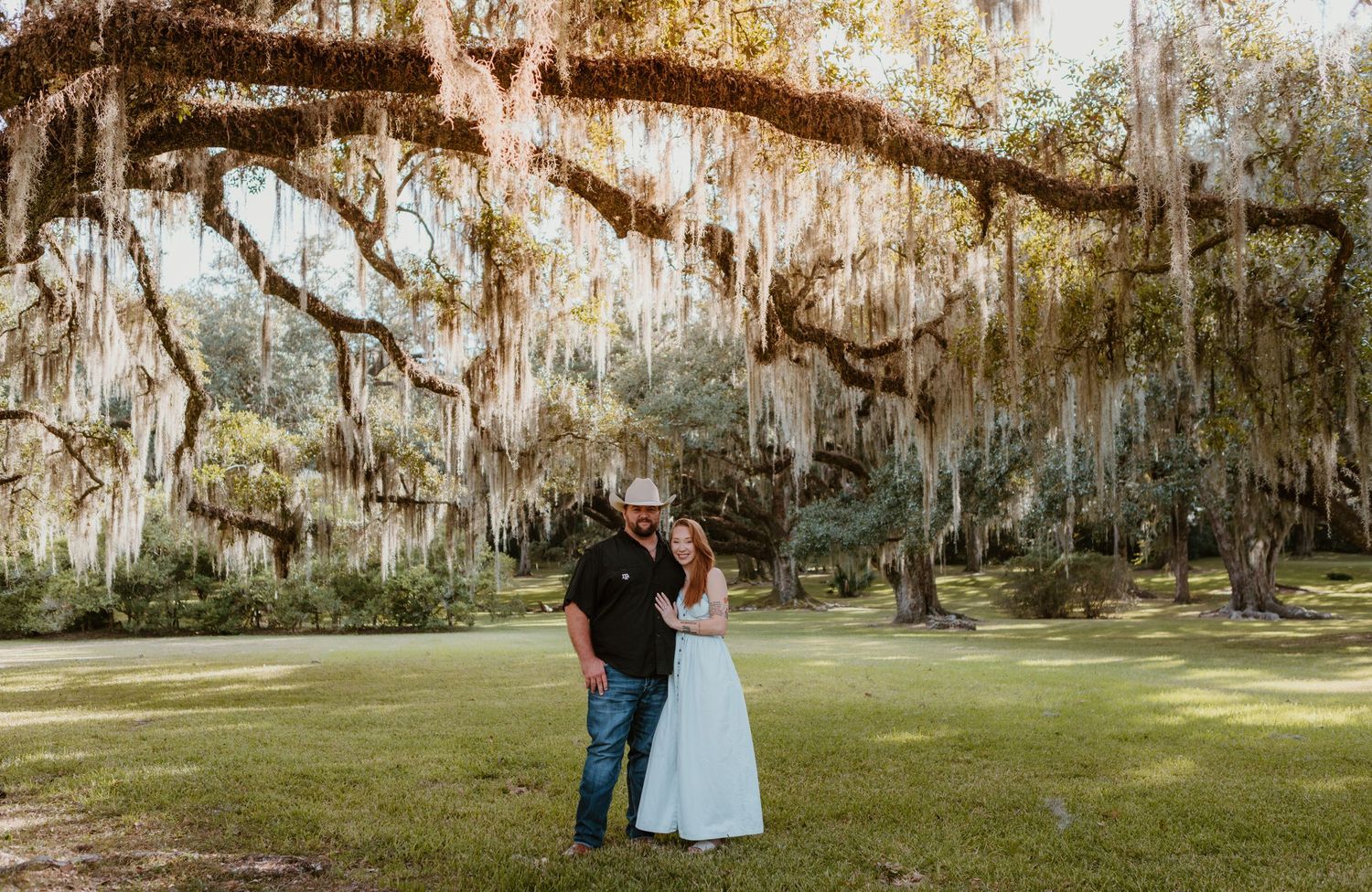Spanish moss draped trees create a romantic backdrop in a Southern garden setting.