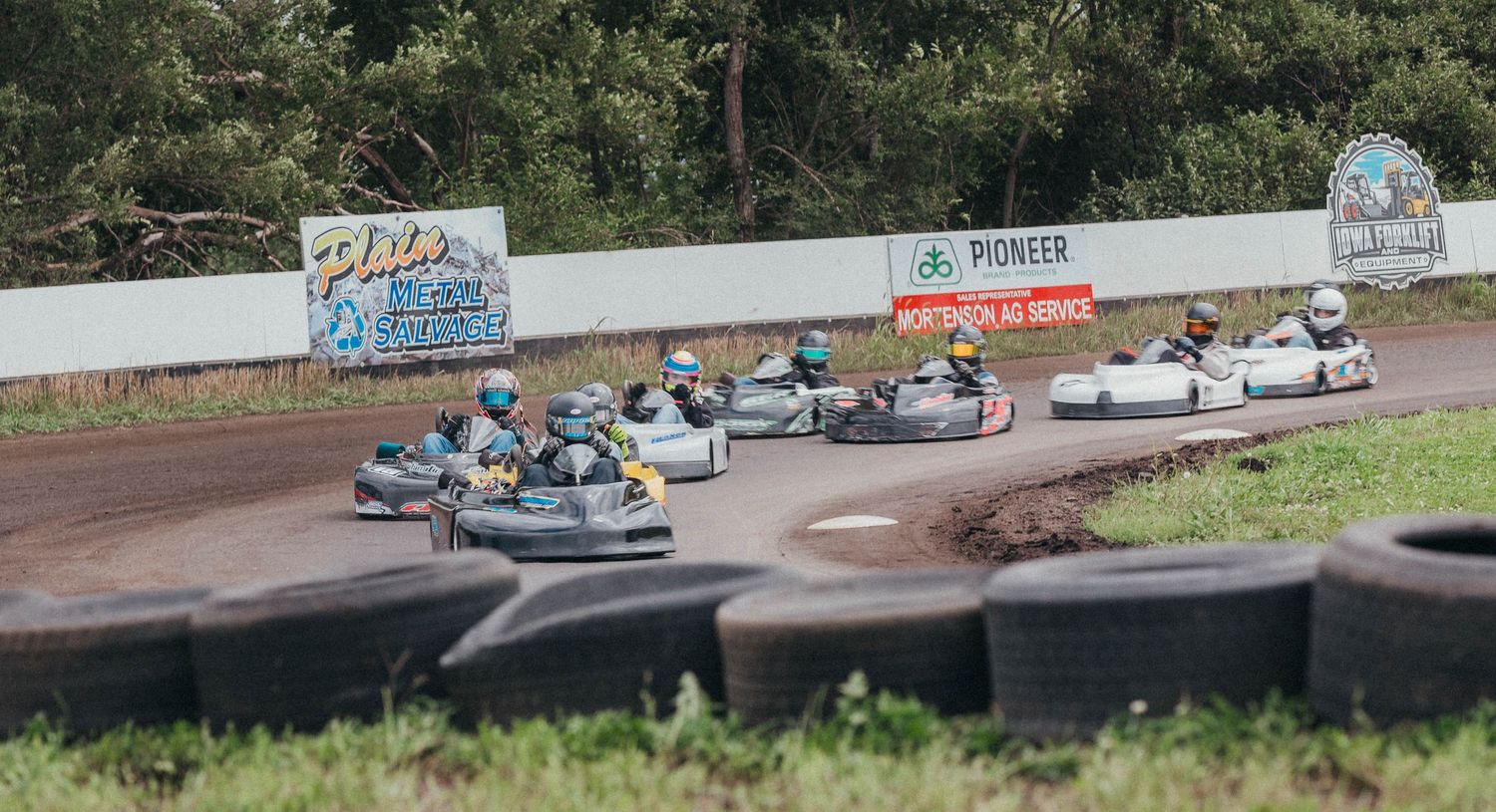 Go-karts battle for position at Poplar Grove Speedway, kicking up dust on a tight turn during heat races