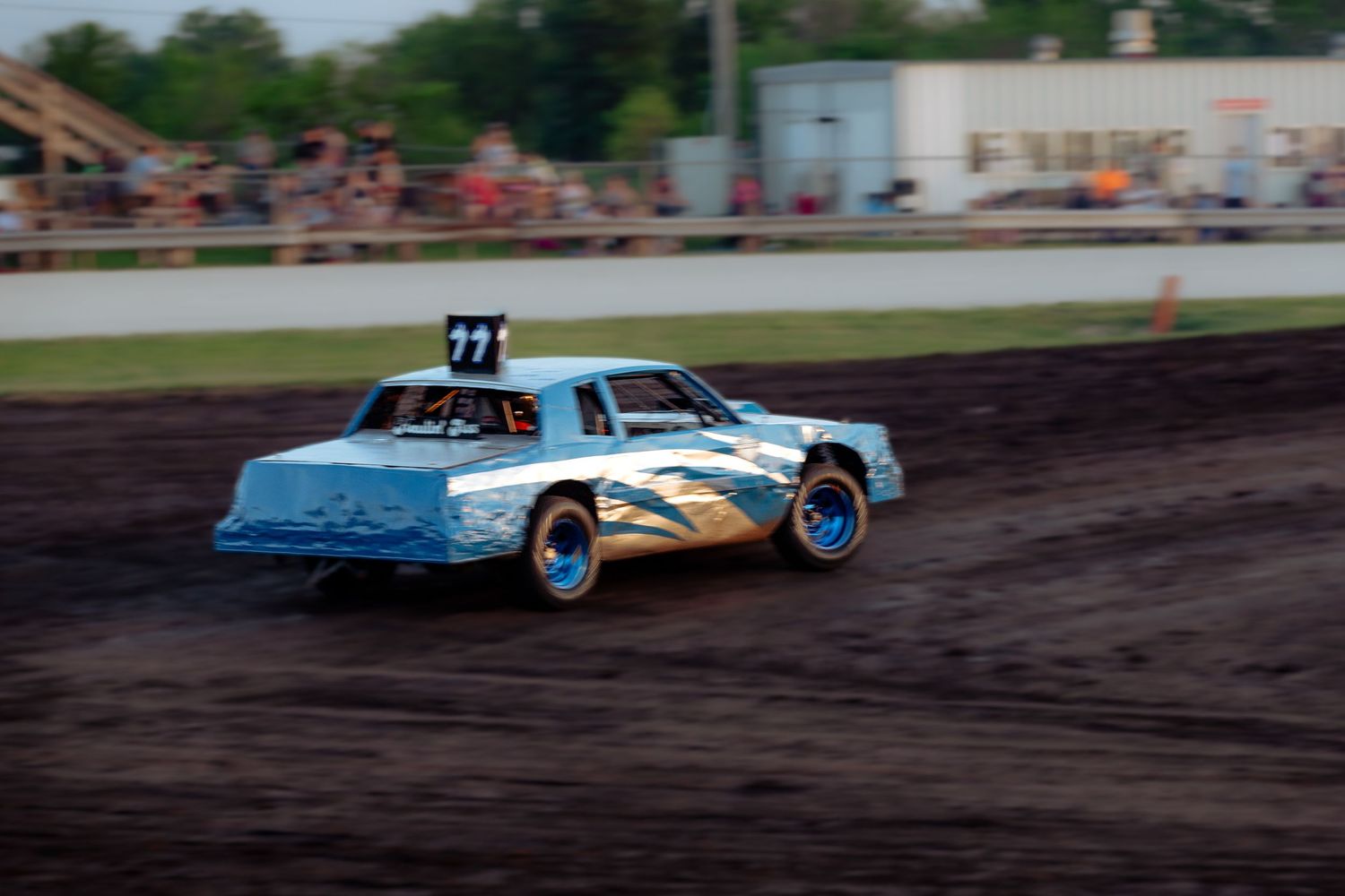 Figure 8 racers tear across the X under the lights at What Cheer Raceway during a packed evening event