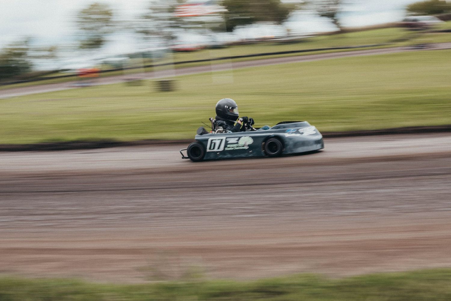 Go-karts battle for position at Poplar Grove Speedway, kicking up dust on a tight turn during heat races