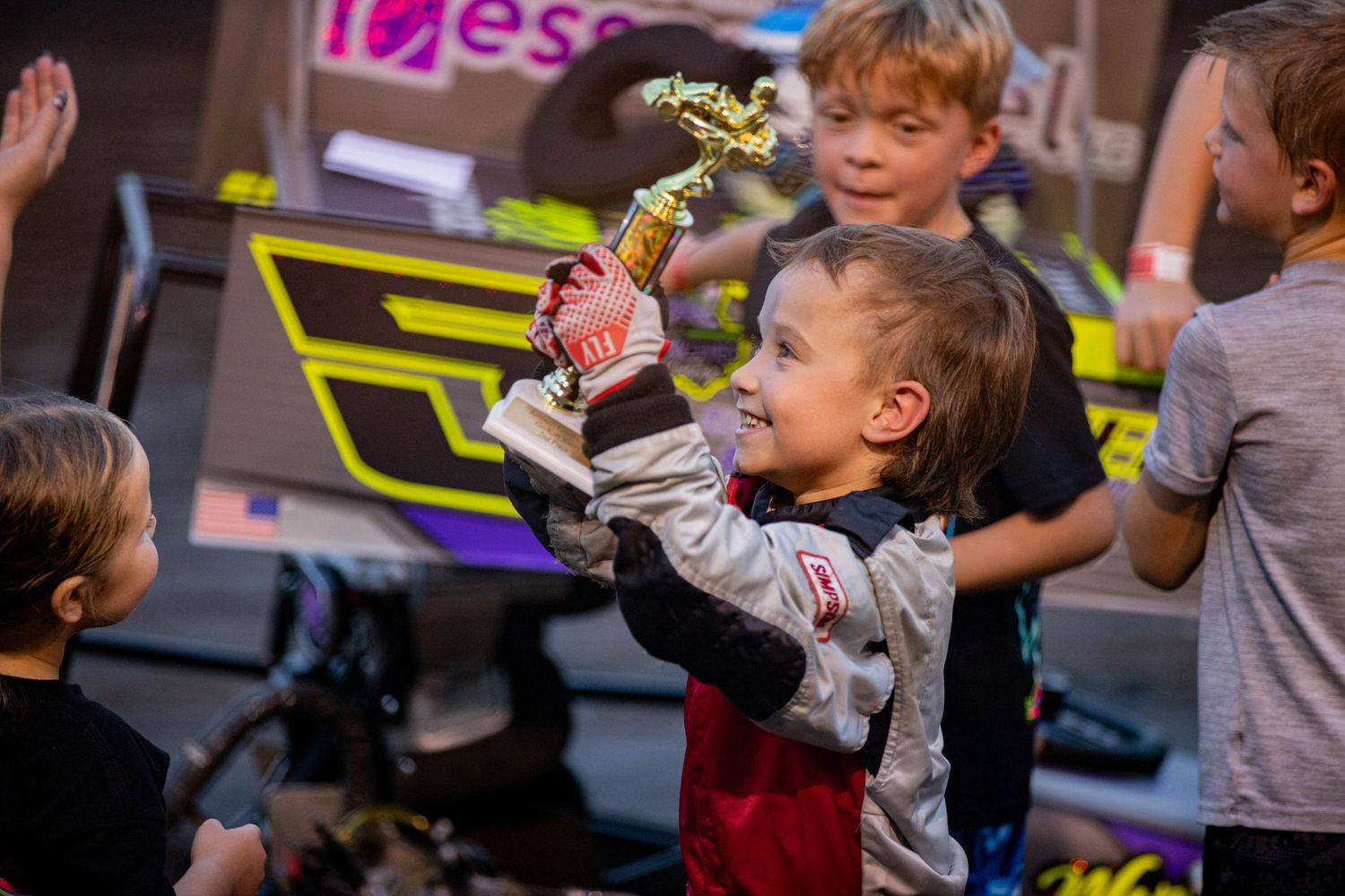 A young racer pilots their go-kart on a dirt track, showing focus and skill during a youth motorsports event
