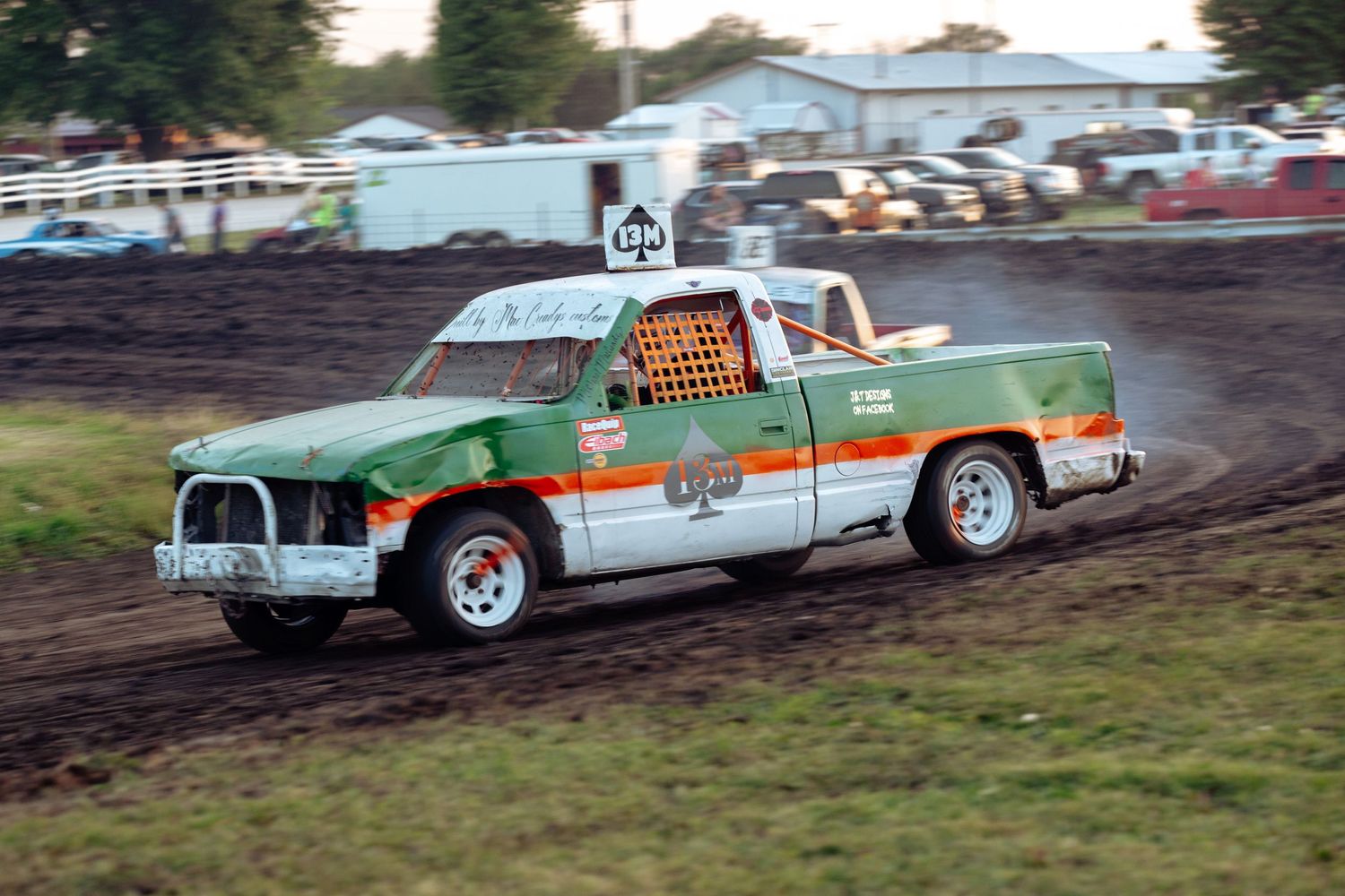 Figure 8 racers tear across the X under the lights at What Cheer Raceway during a packed evening event