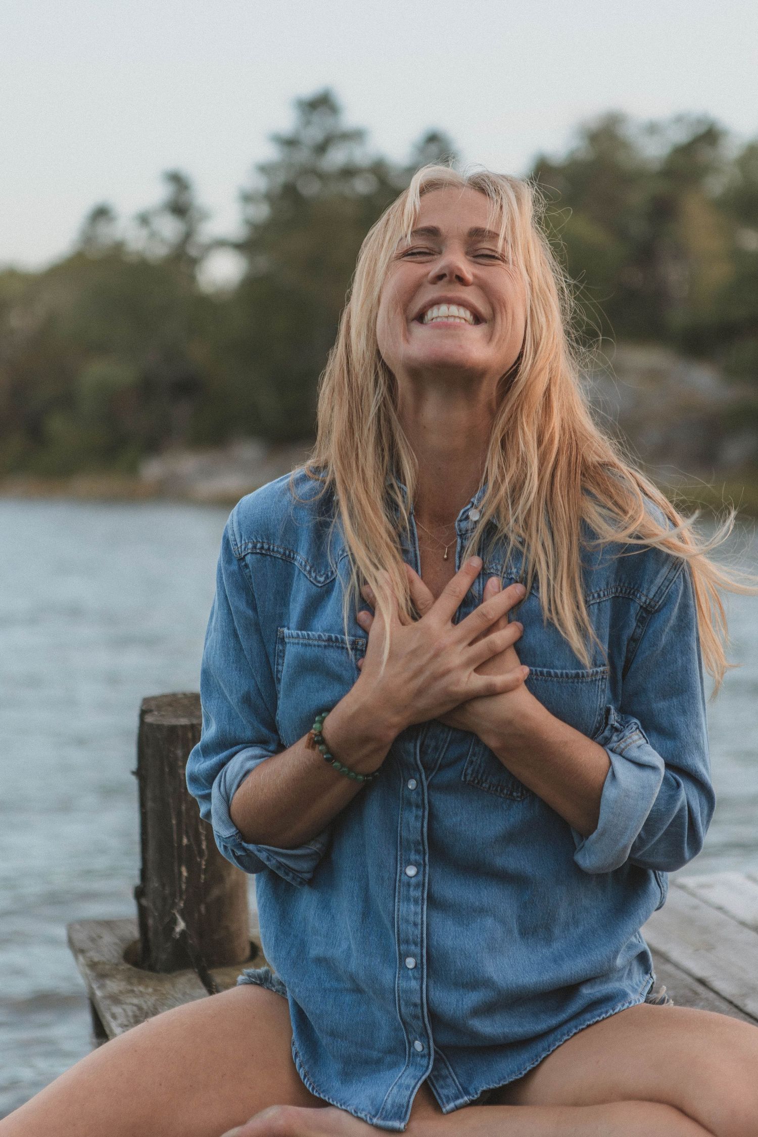 Joyful moment captured of someone in denim shirt by waterfront.