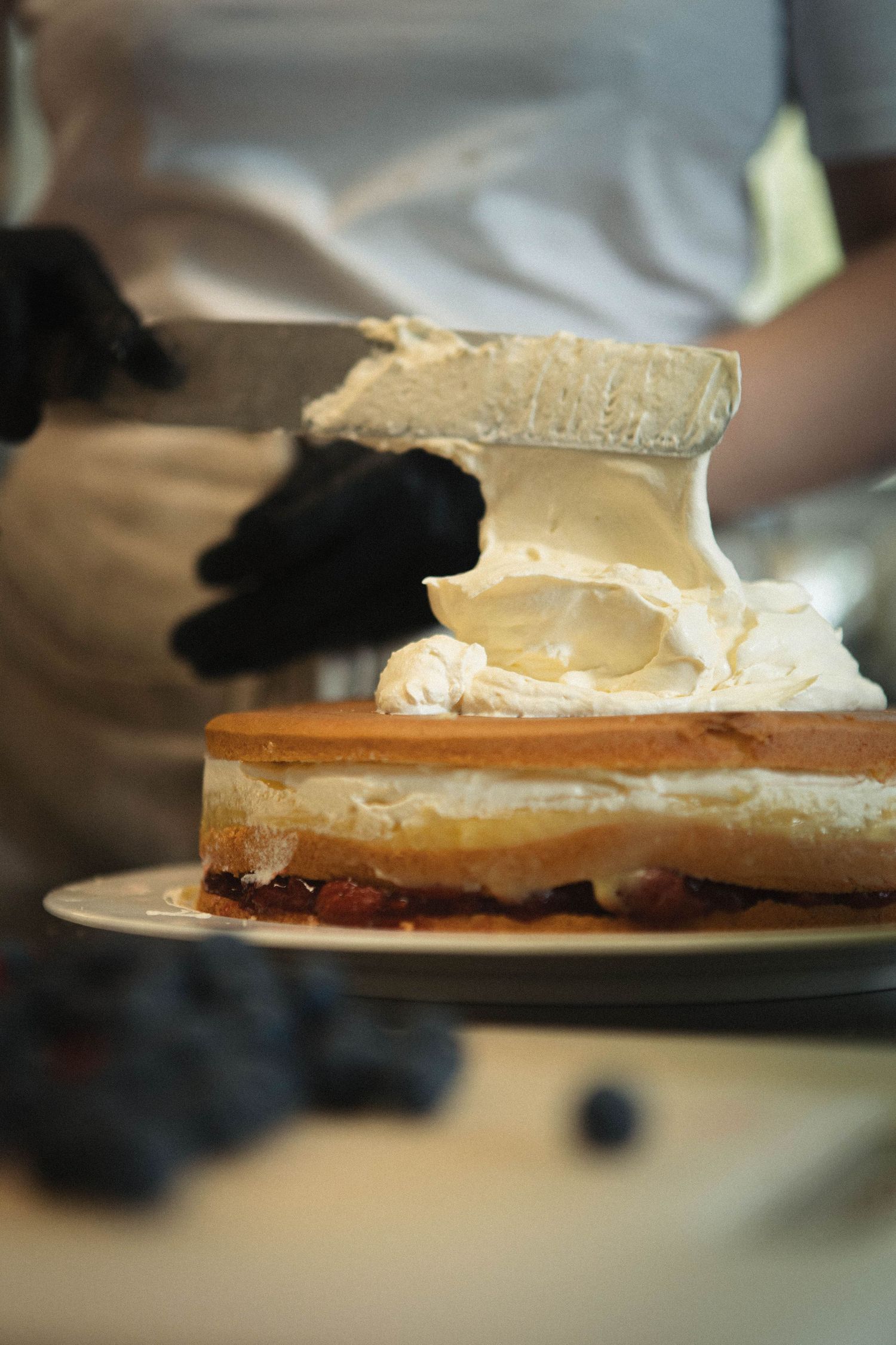 Close-up of a creamy cheesecake slice being served on a white plate.