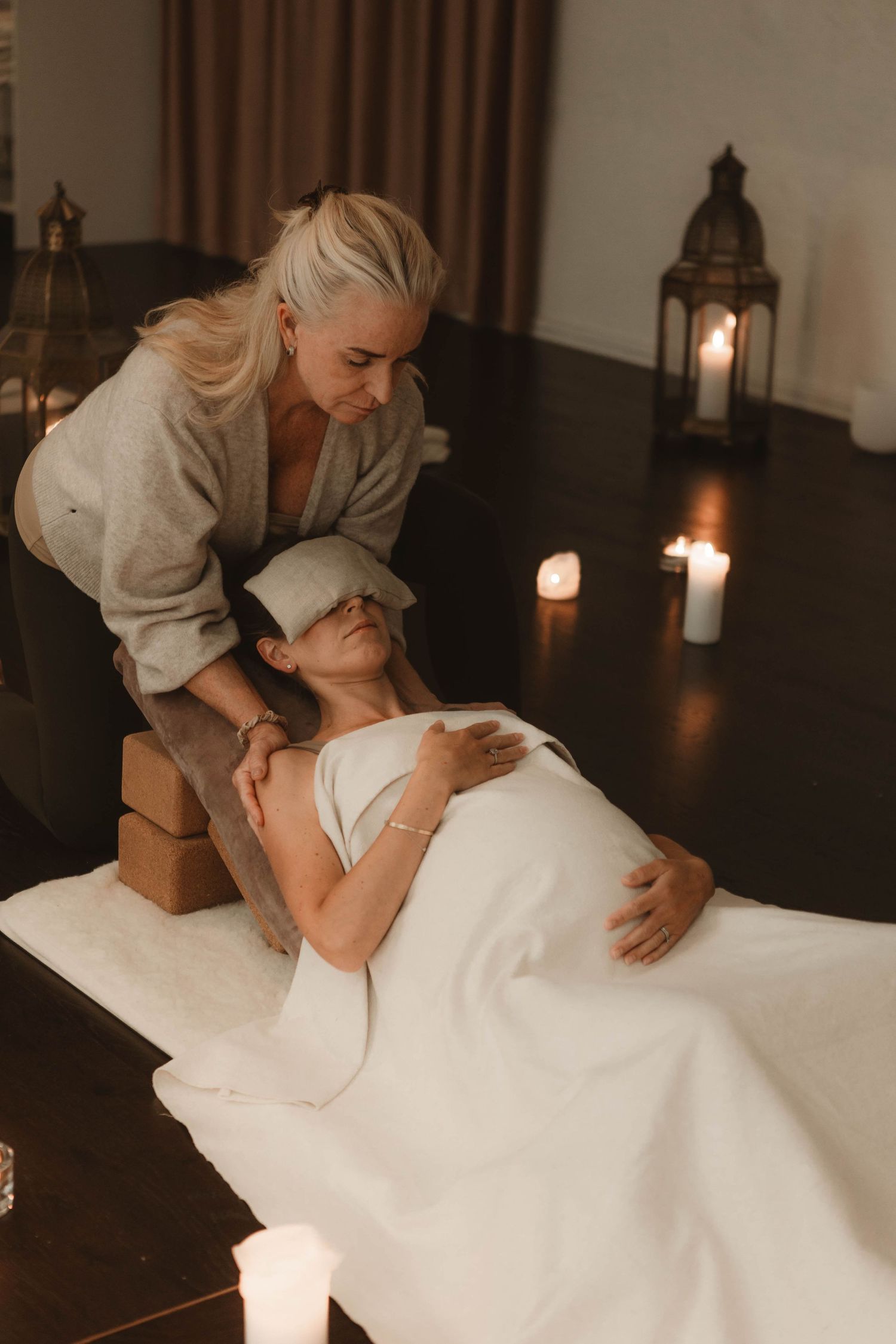 A relaxing massage therapy session by candlelight with white draping.
