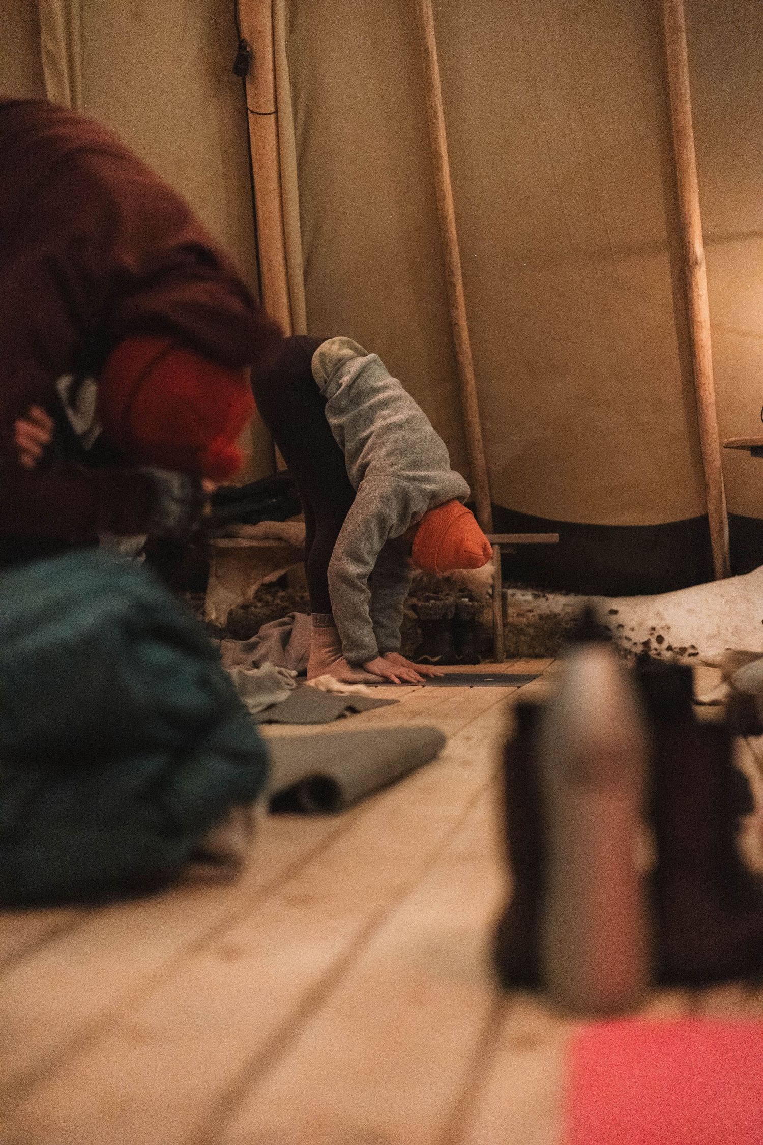 Someone prepares food or items inside a cozy tent interior with warm lighting.