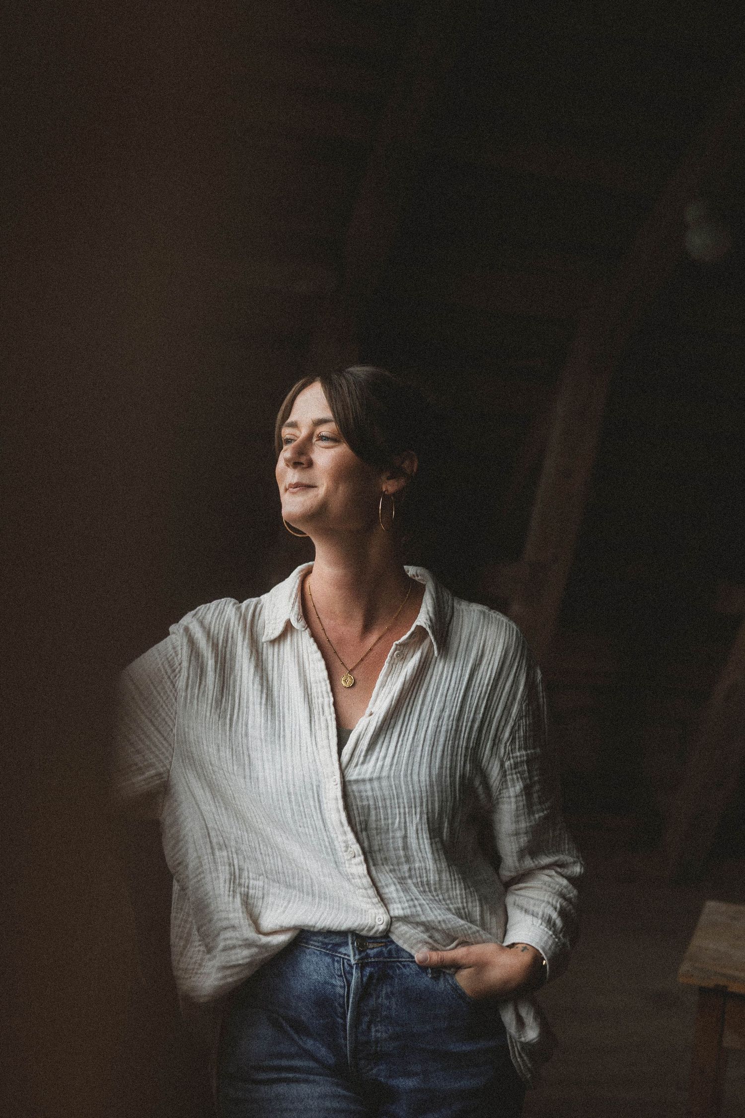 A series of moody portraits in a white shirt and jeans creating an expressive sequence against a dark background.