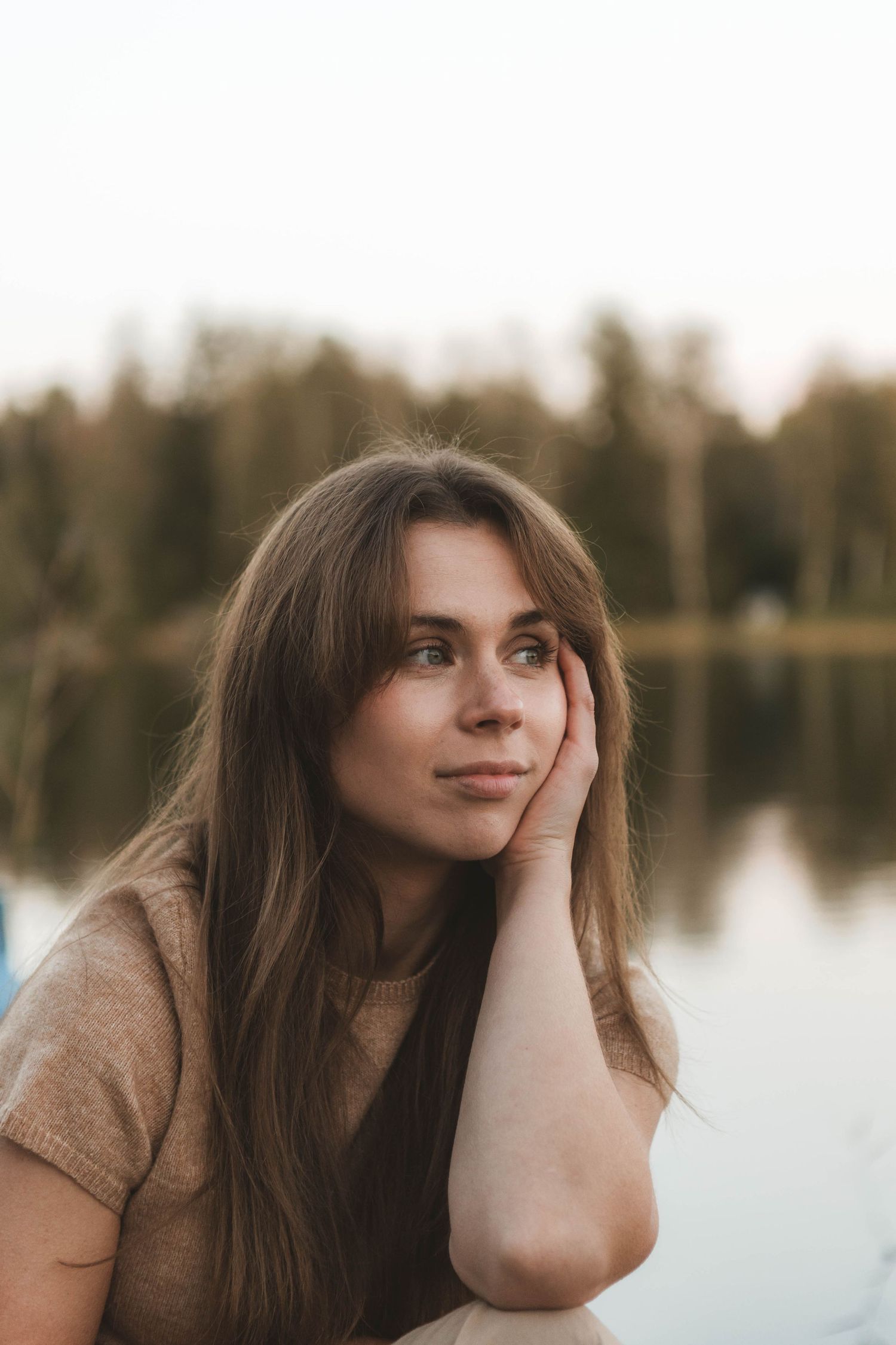 A collection of artistic portrait shots showing contemplative poses against a blurred lake background.