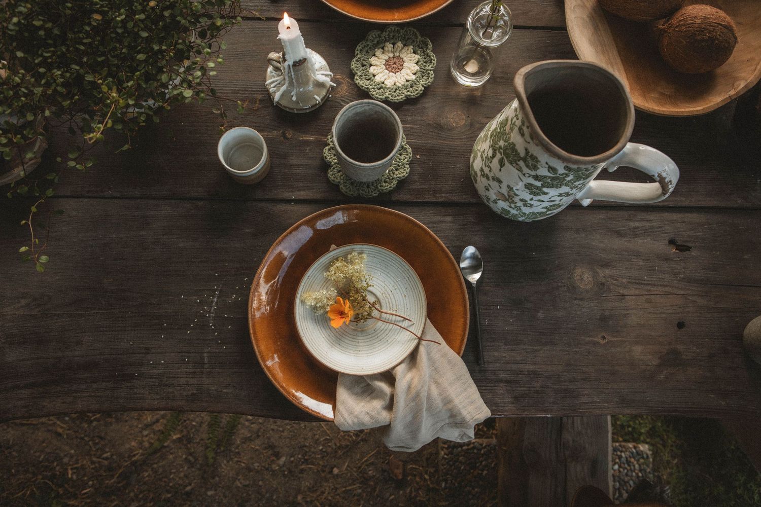 Overhead view of coffee and breakfast items arranged on a dark wooden table.