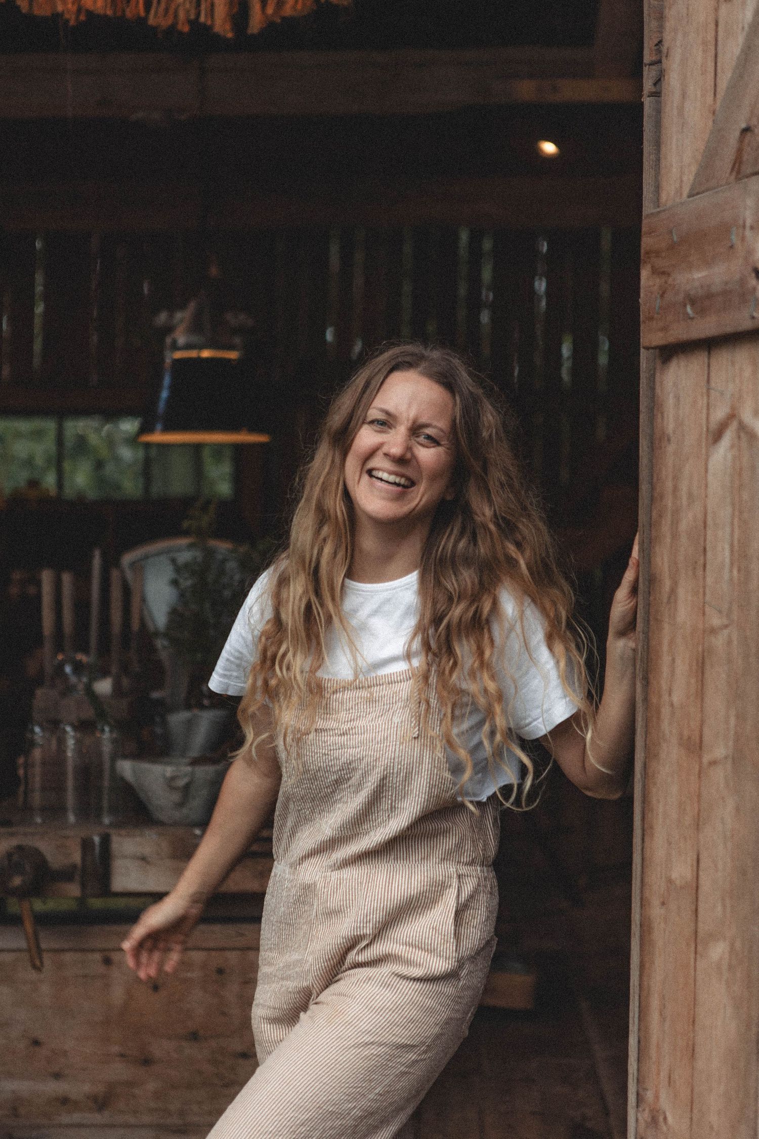 Candid moment in a rustic barn setting with joyful movement and natural light.