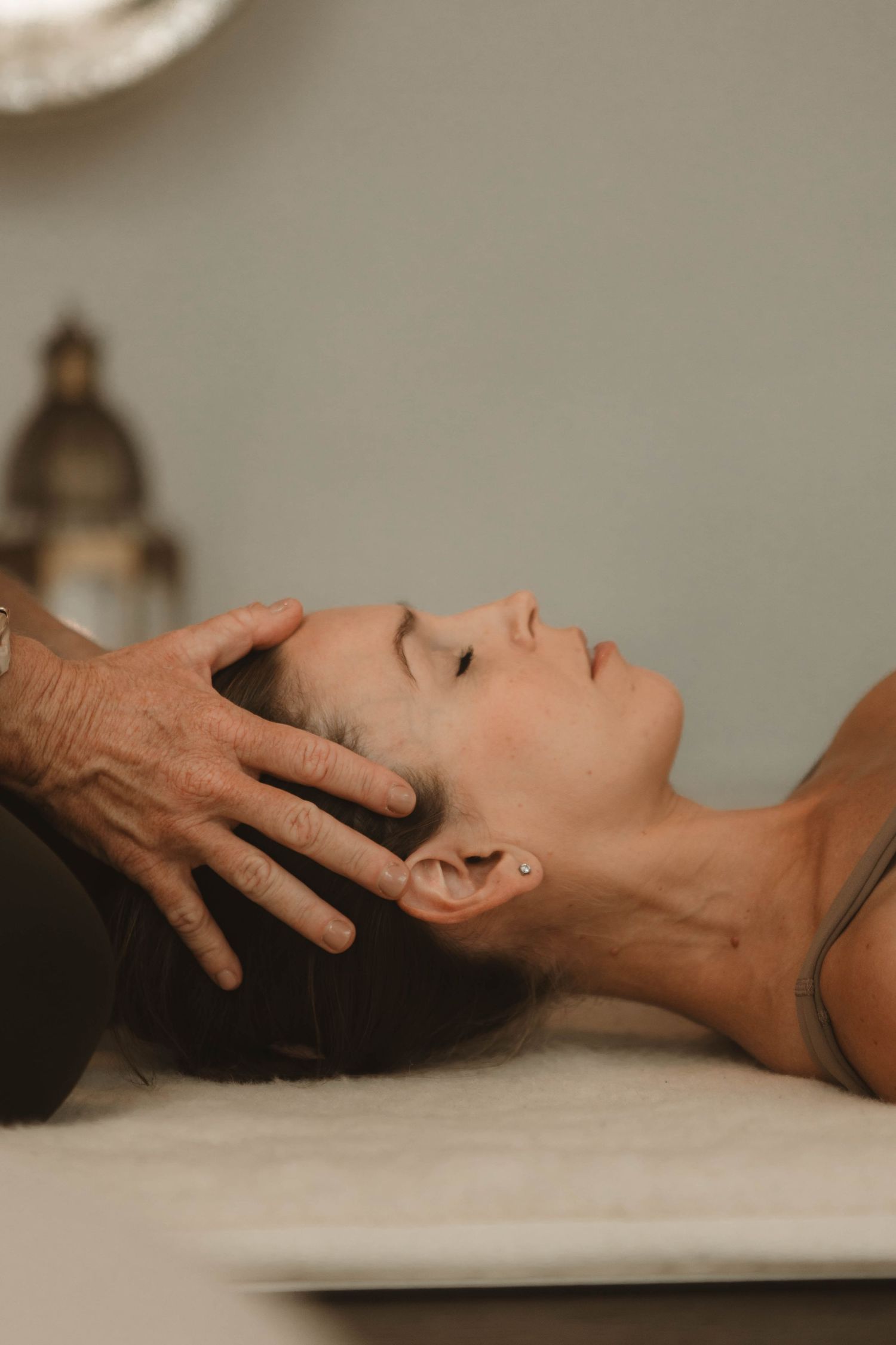 A person receiving a relaxing head massage while lying on a treatment table.