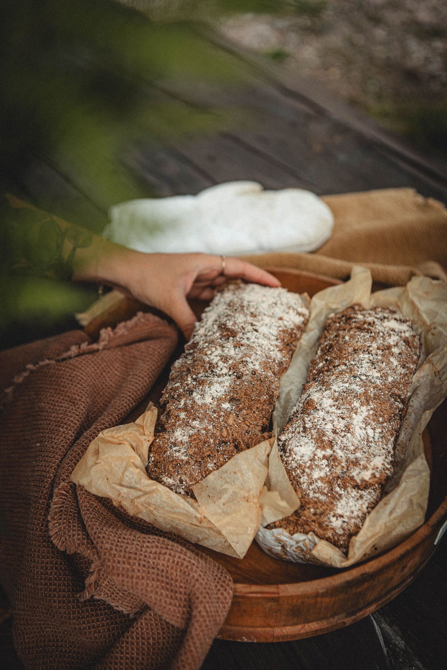 Freshly baked artisan bread loaves dusted with flour on brown paper and textile.