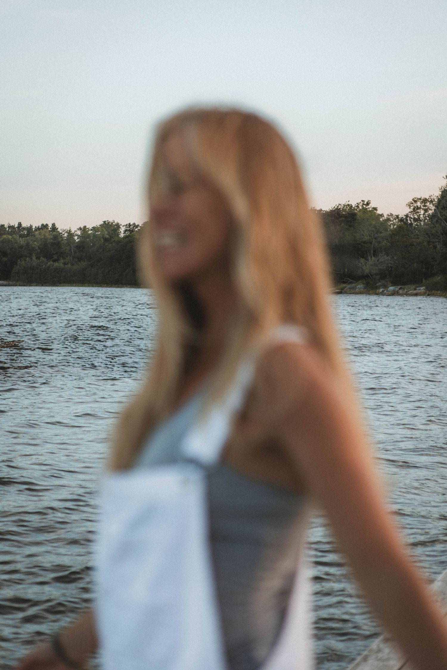 Dreamy unfocused portrait by the water with soft natural lighting.