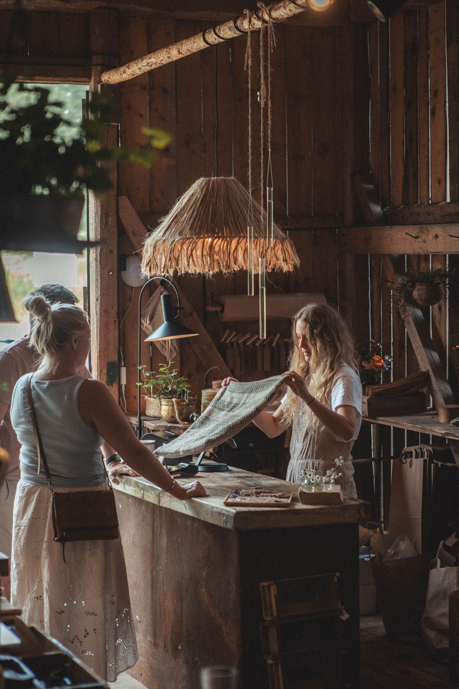 Rustic workshop interior with fringe lampshade and wooden counter setup.