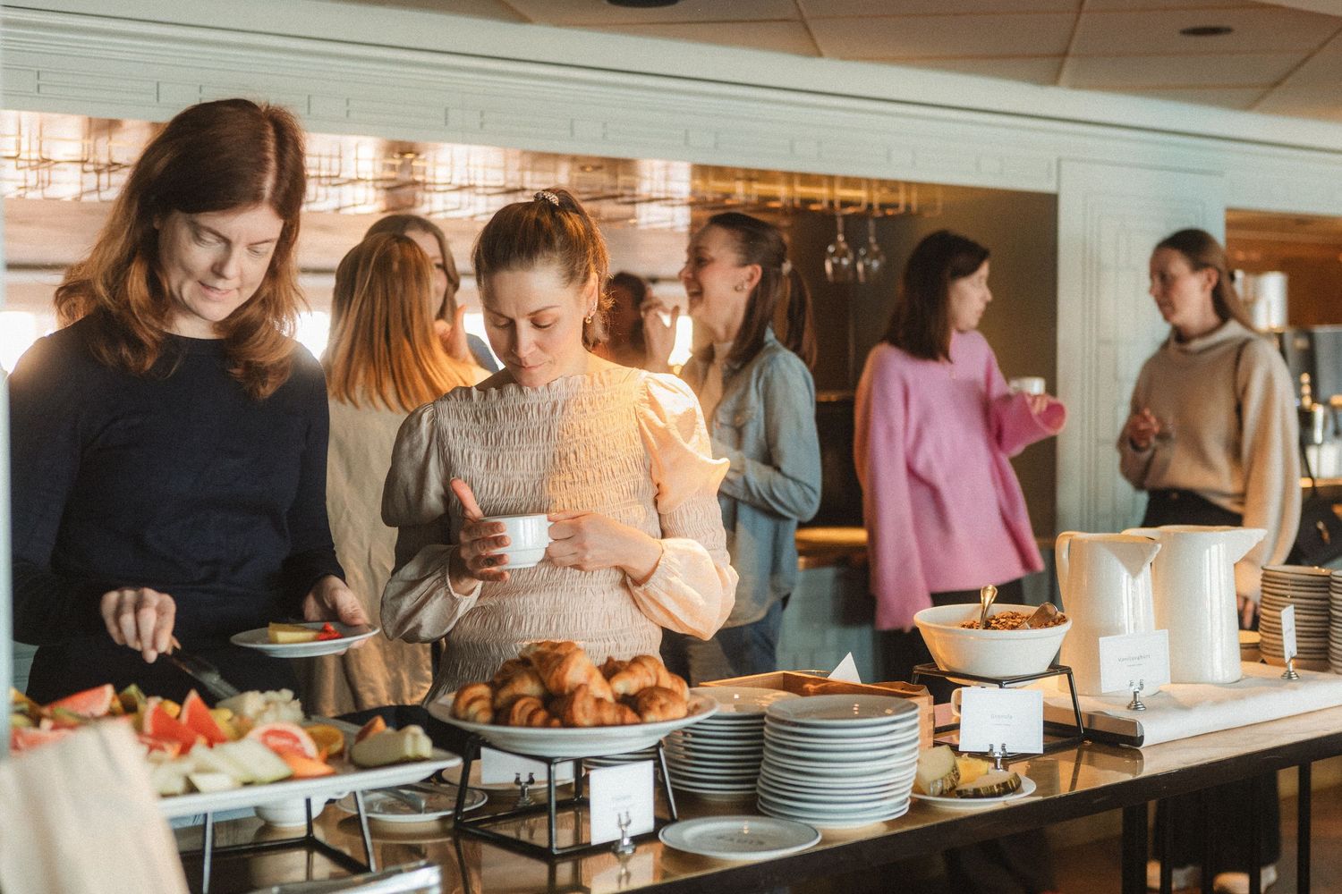 A busy buffet line with people serving themselves food at a restaurant counter.