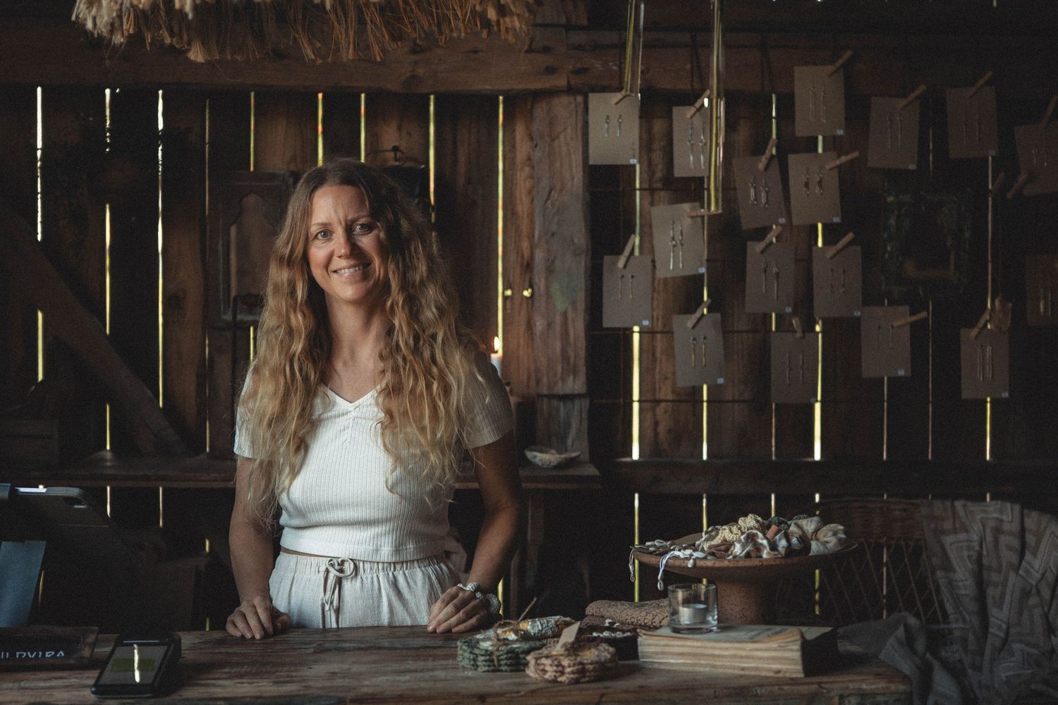 Person in white dress working at rustic wooden workstation with vintage decor.