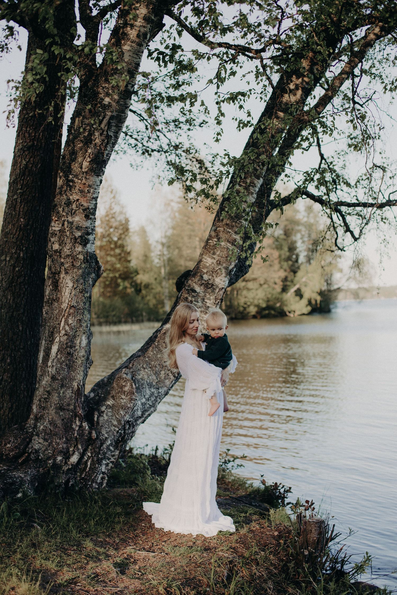 Romantic lakeside photography session among birch trees at sunset.