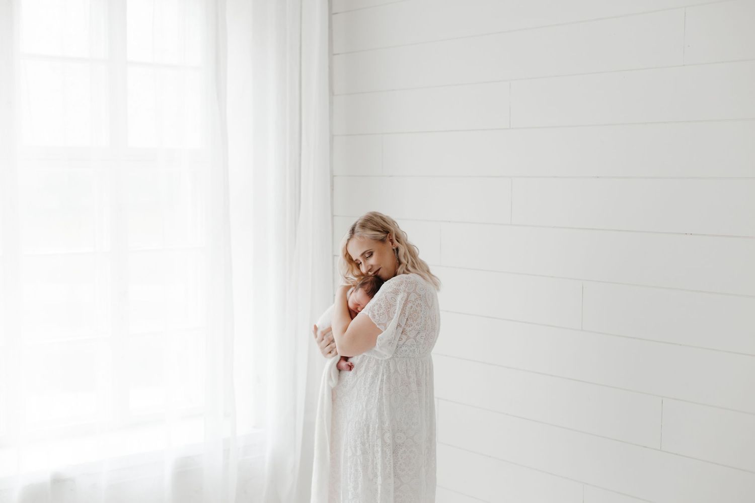 Family members share joyful moments in bright white studio setting.