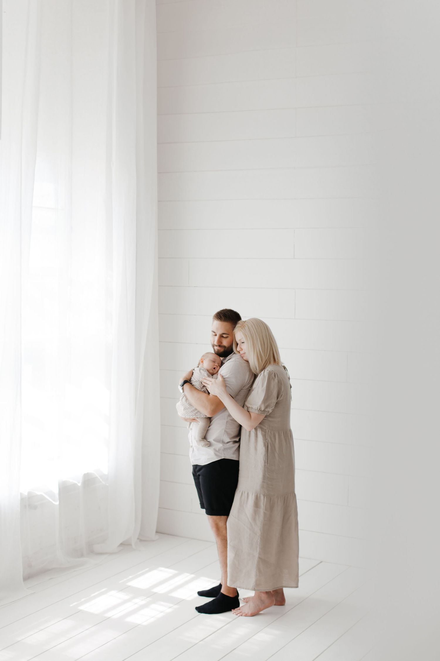 Artistic family portrait with dramatic lighting and clean white background.