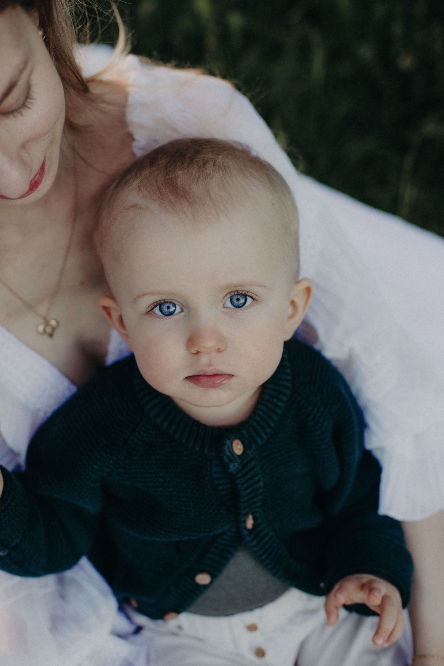 Close-up portrait showing delicate details and navy sweater buttons.