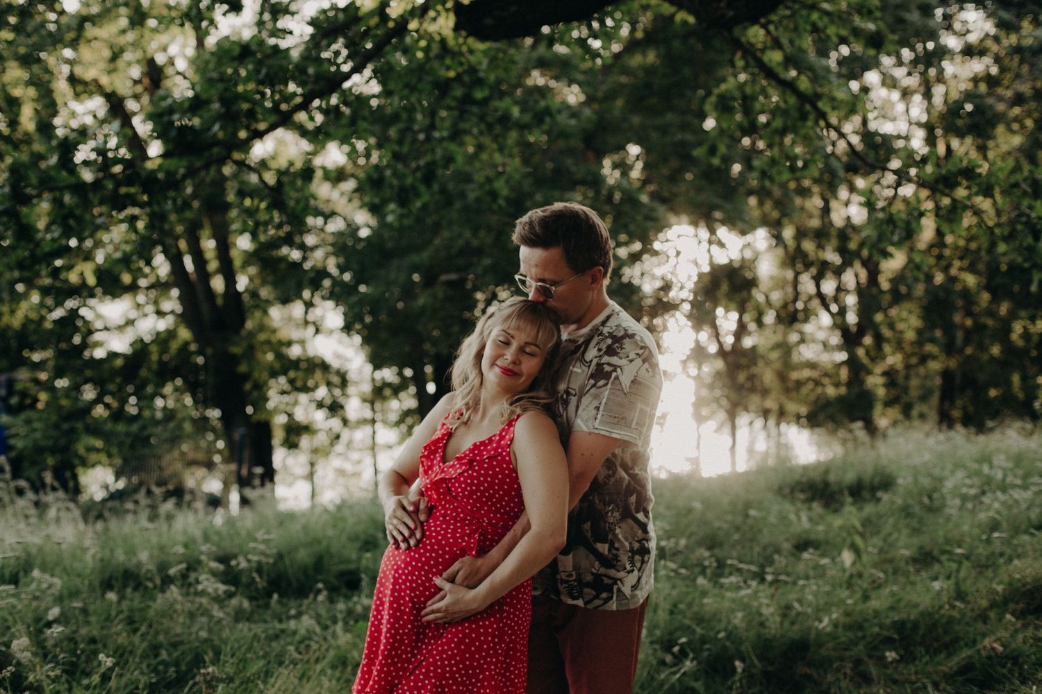 Intimate outdoor portrait session with sunlight filtering through trees.