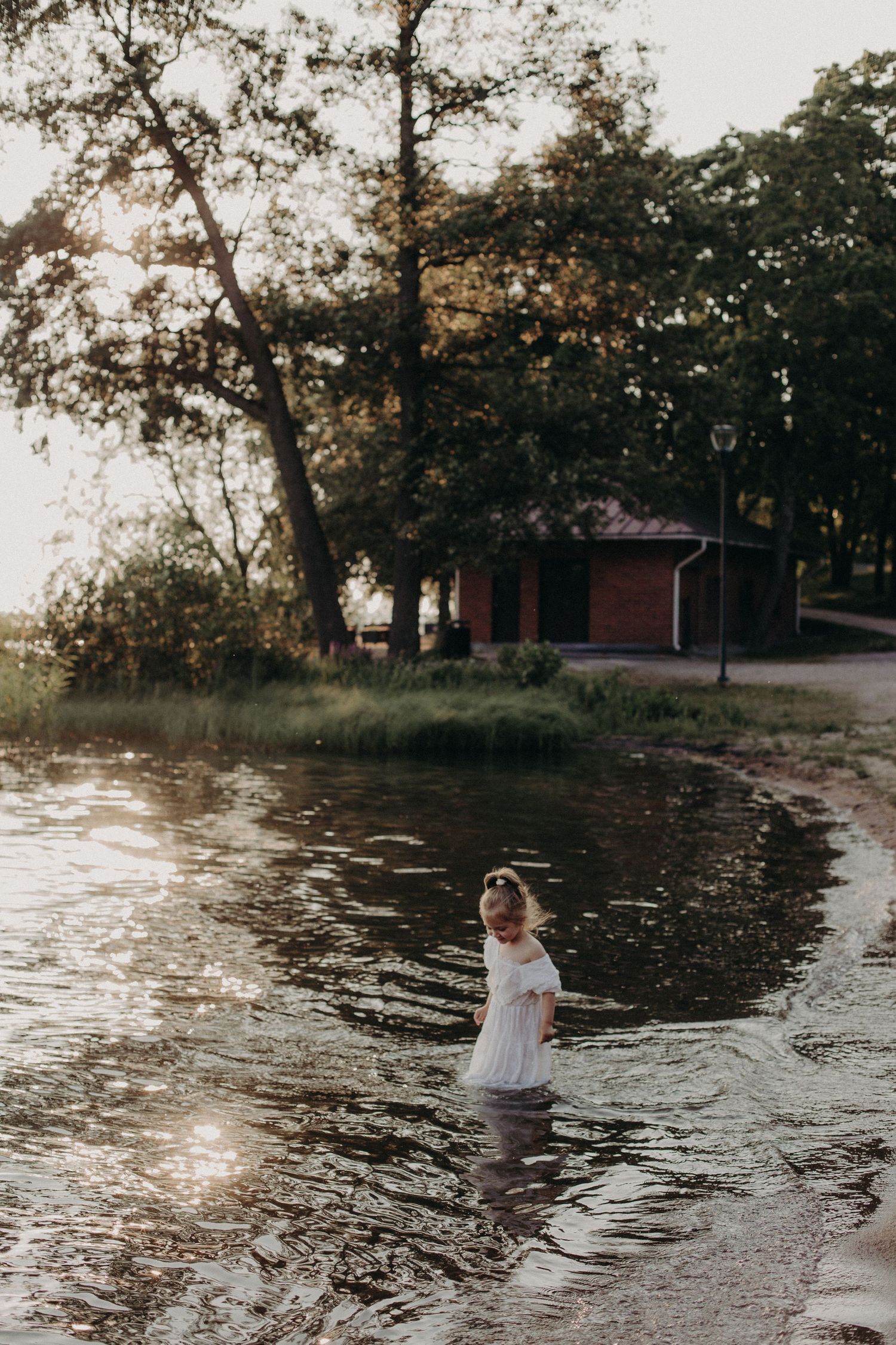 Scenic lake view with trees and person near water at sunset.
