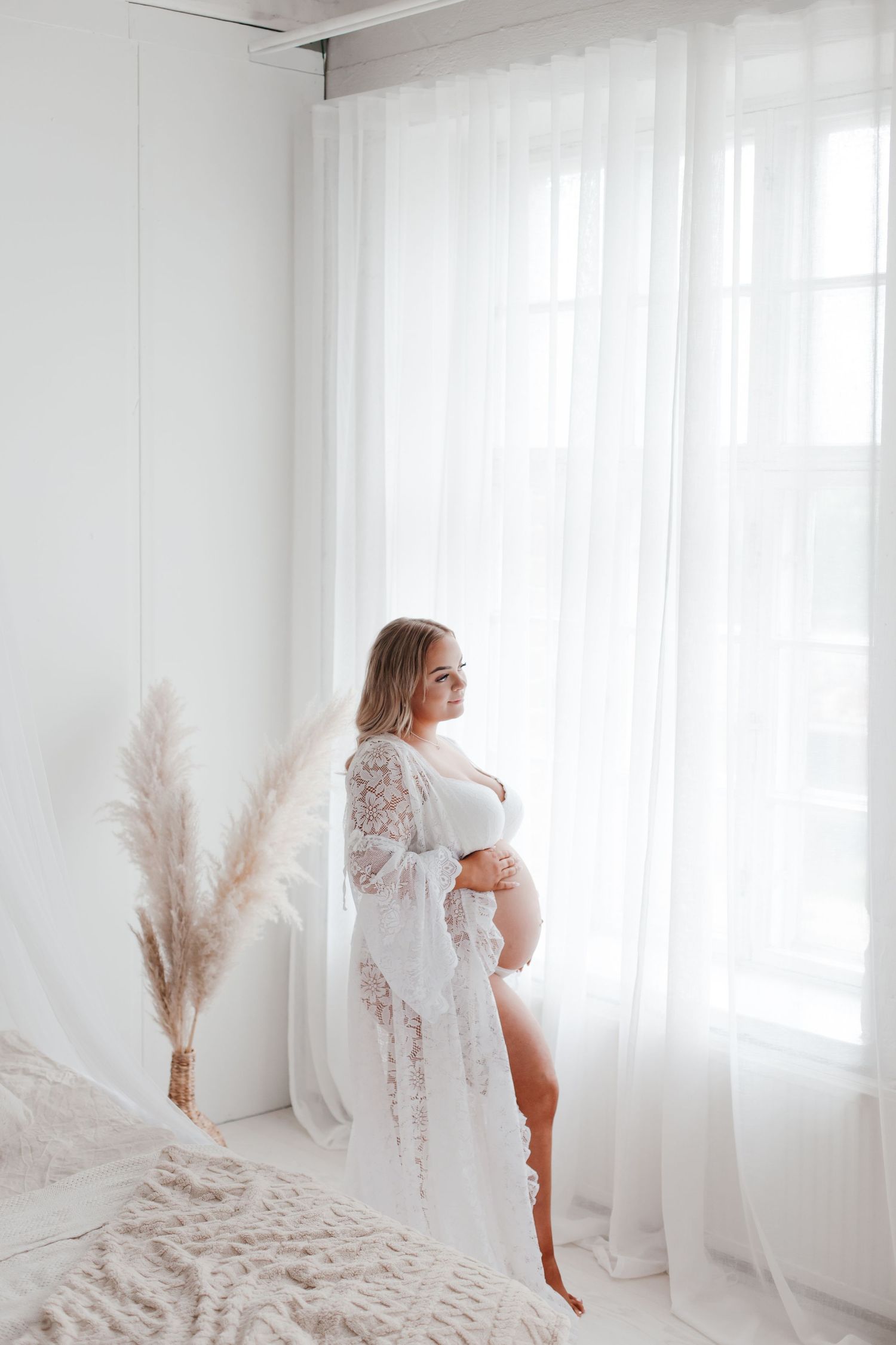 Artistic maternity portraits in minimalist white studio with natural light.